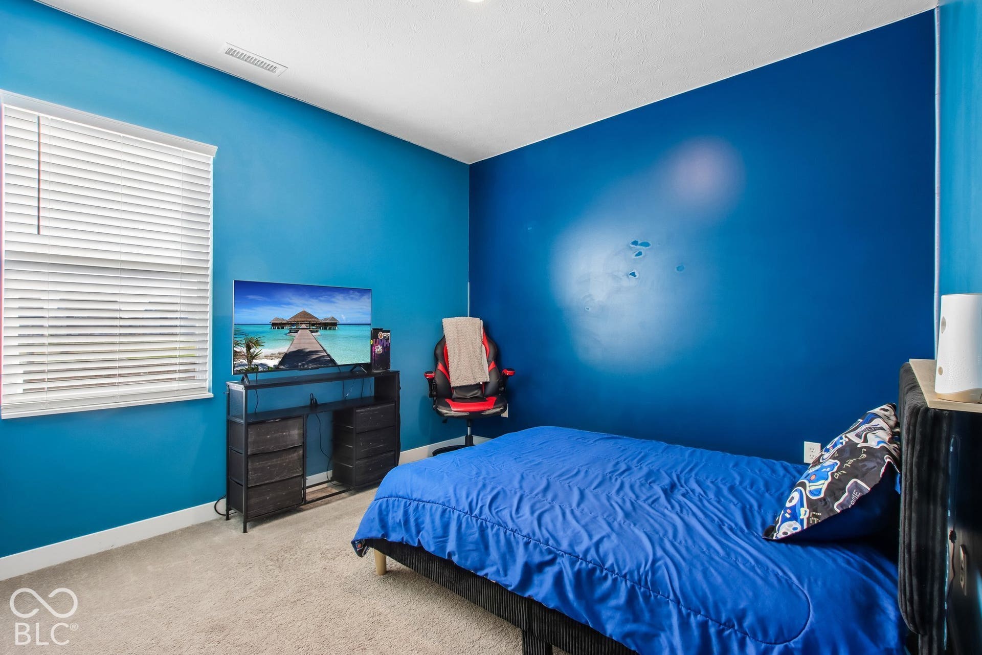 Window with horizontal blinds, light neutral-toned carpeting, and blue painted walls
