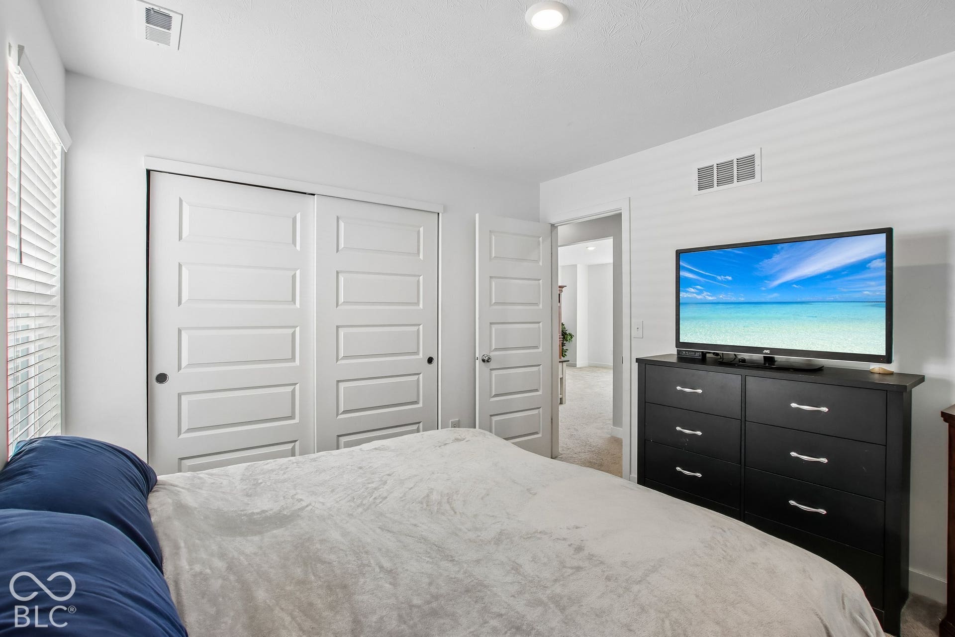 Recessed ceiling lighting, white blinds, and interior doors with paneled detailing