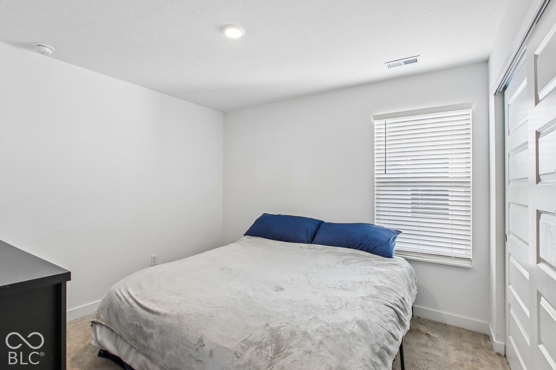 Recessed lighting, window with blinds, carpet flooring, and sliding panel closet doors