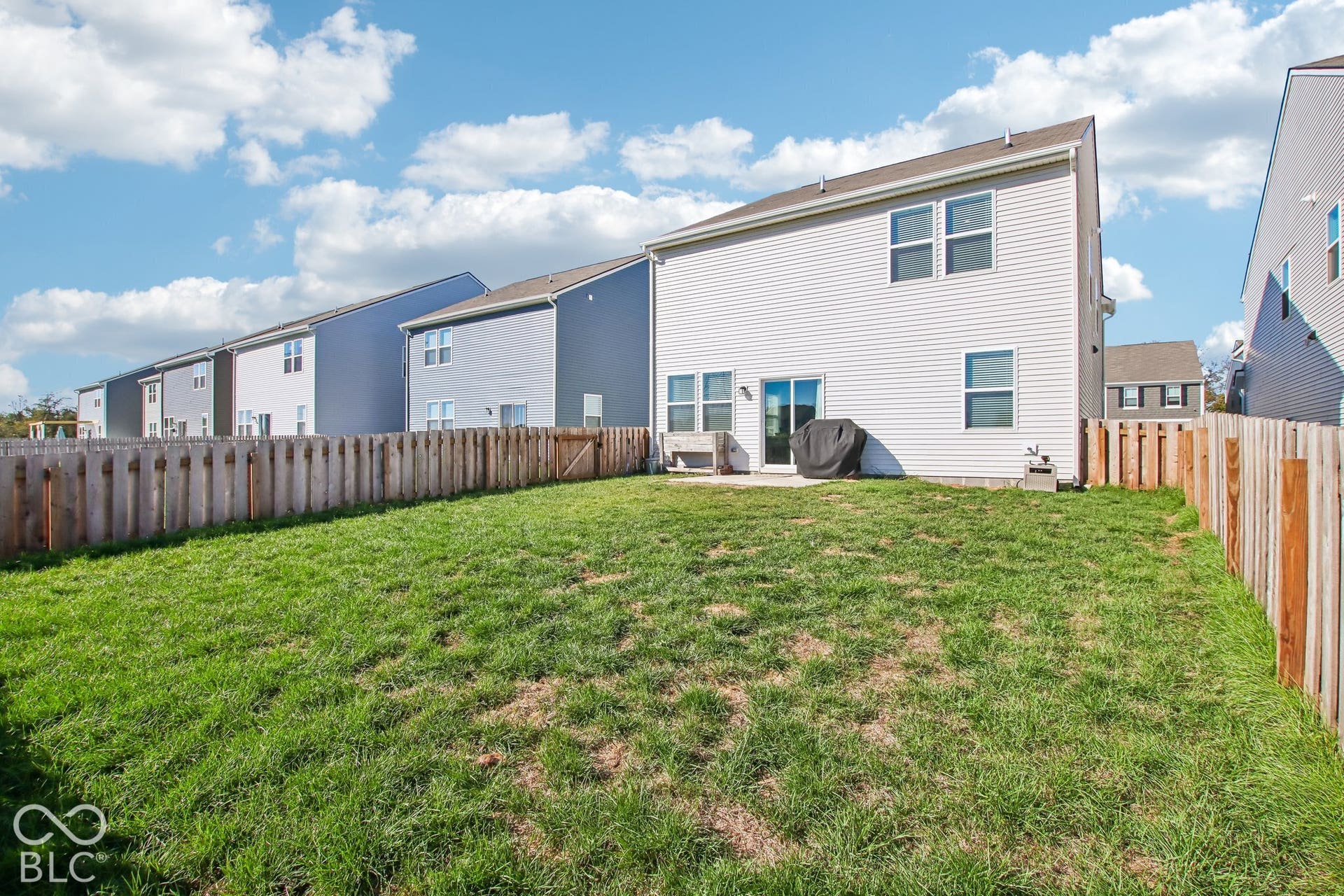 Expansive backyard with a wooden fence enclosing a grassy area