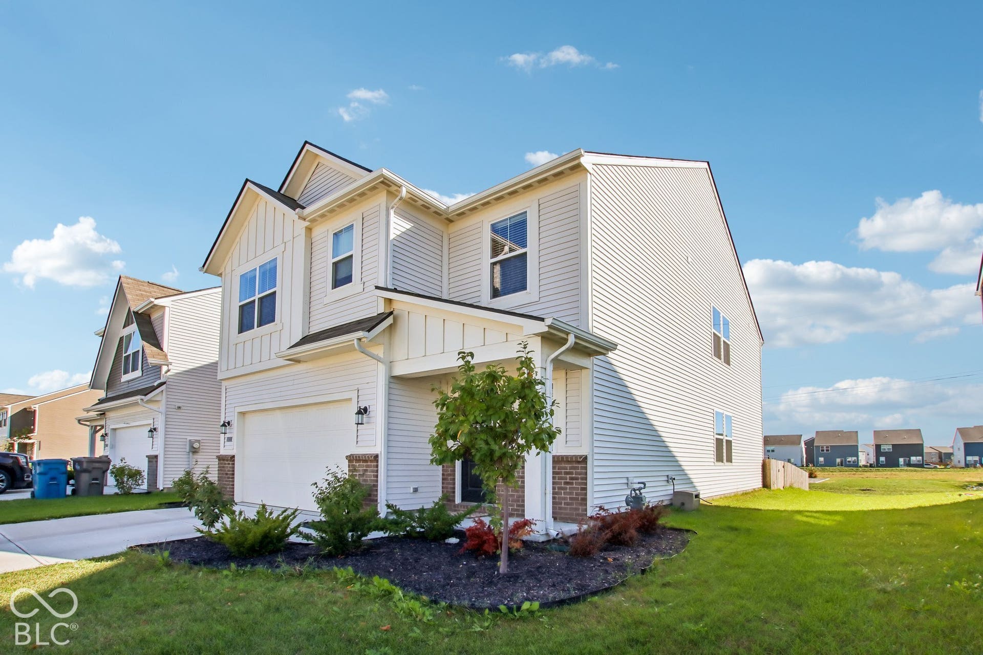 Two-story exterior with light-colored siding and dark trim accents