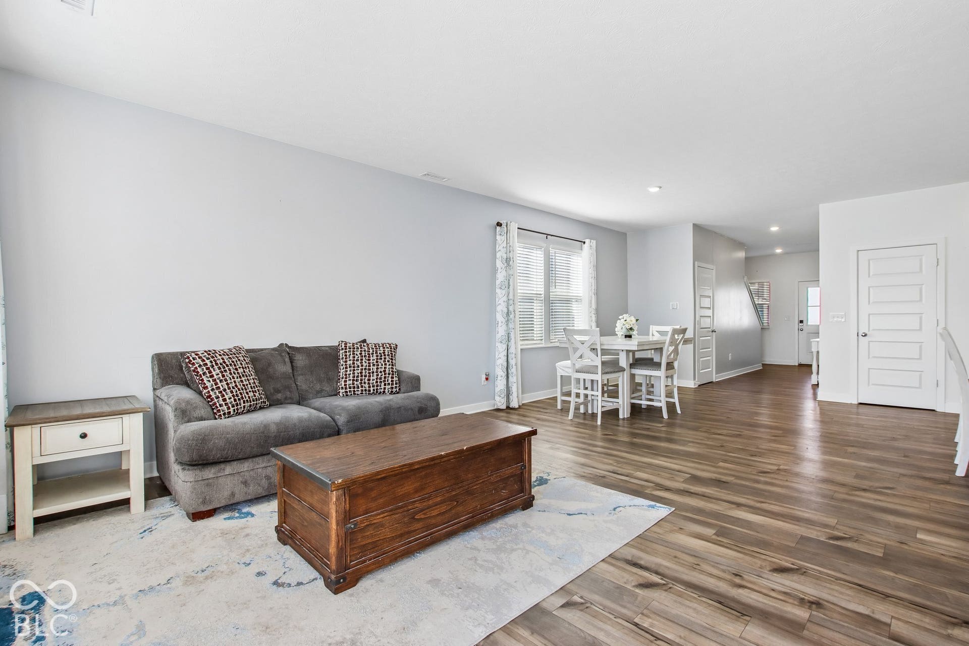 Open-concept living space featuring wood-finish flooring, recessed lighting, and light gray wall tones