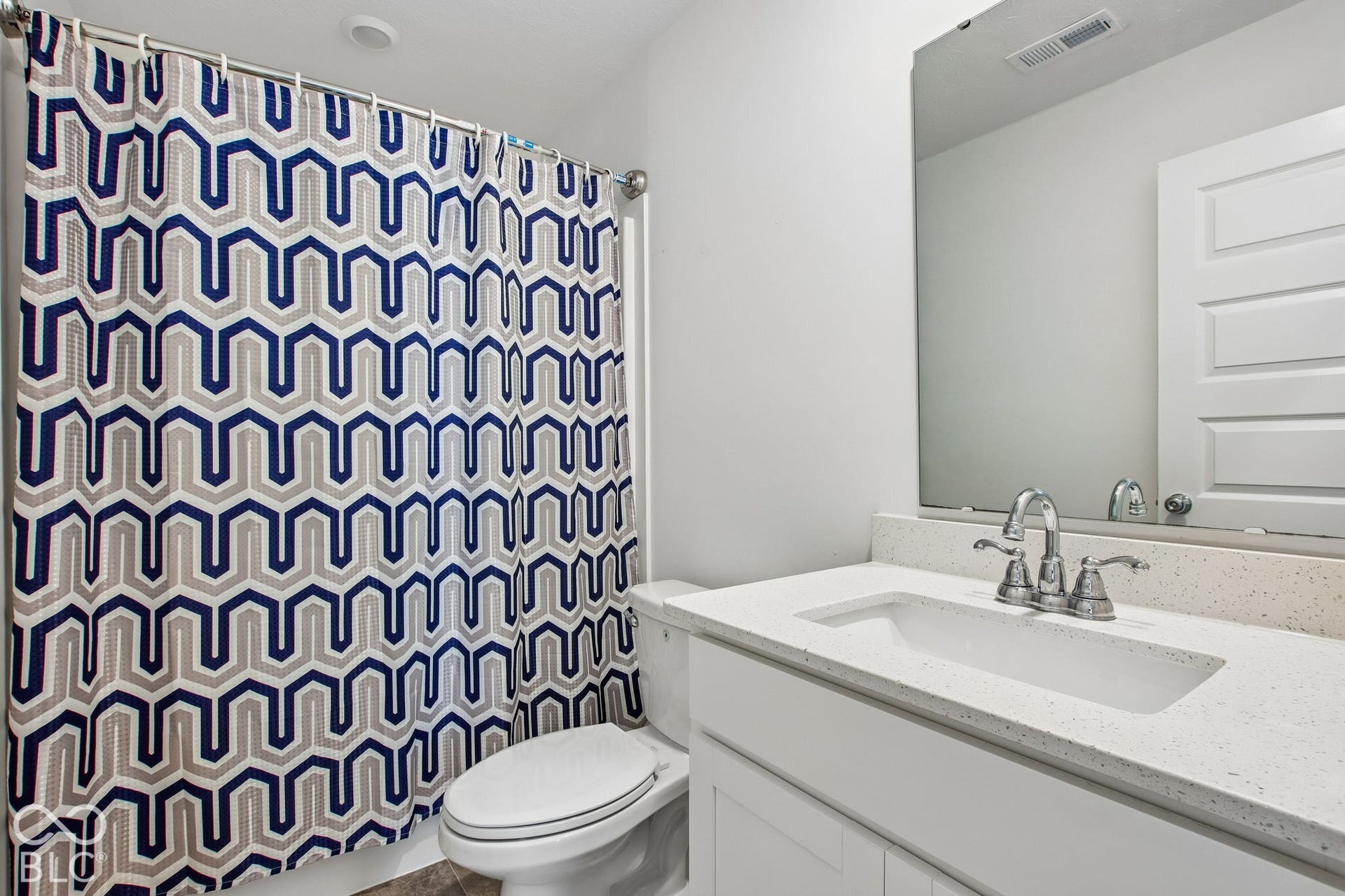 White vanity with a light-colored countertop and integrated sink