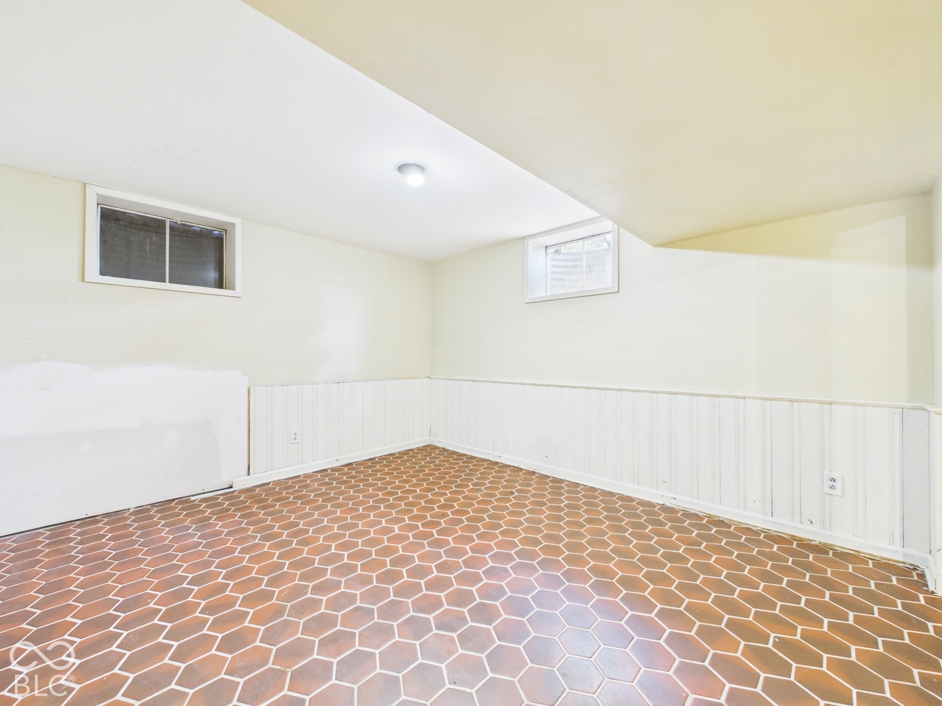 Recessed lighting, two windows, wainscoting, and hexagonal floor tile