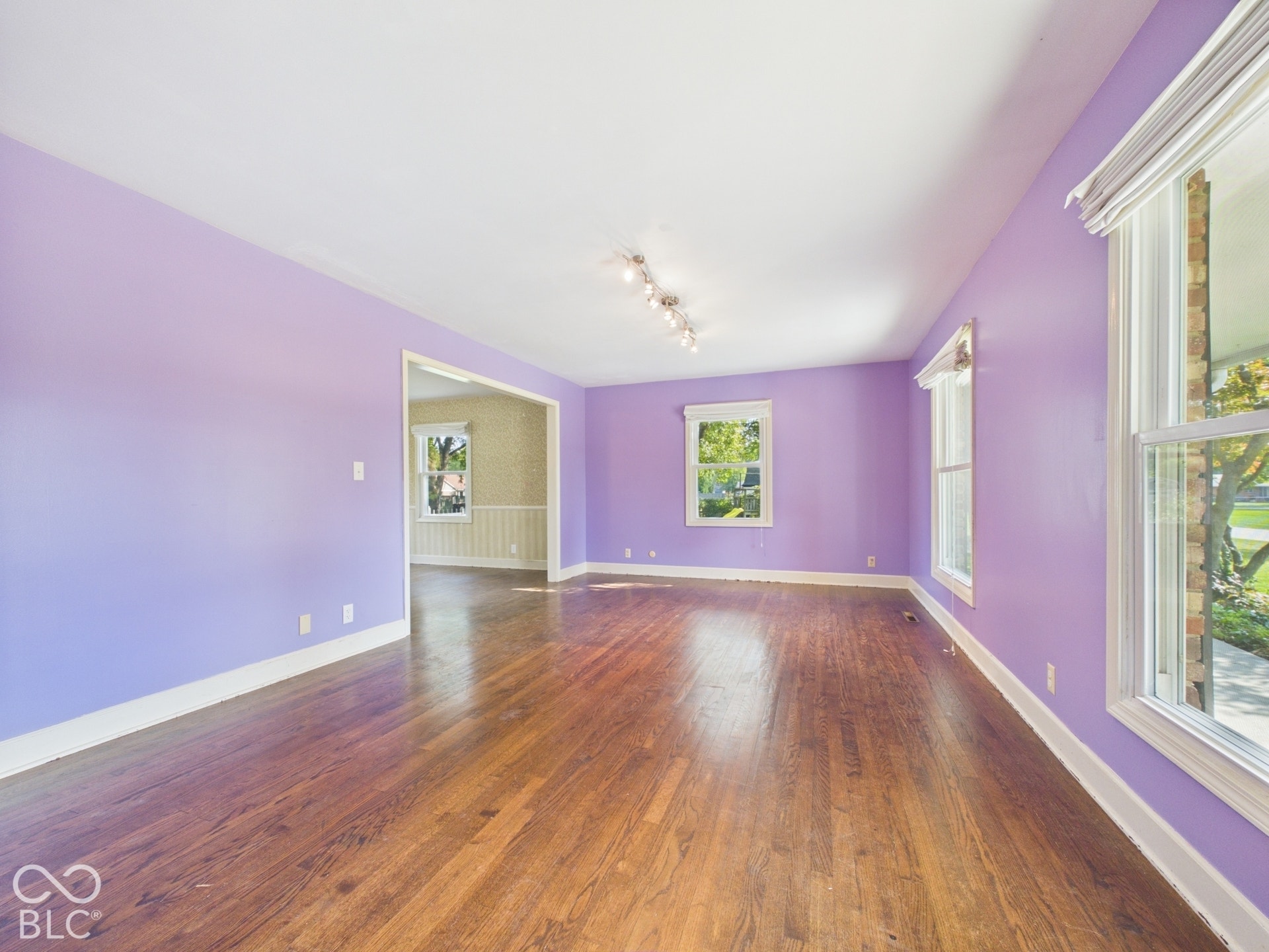 Hardwood flooring, multiple windows, track lighting fixture, cased doorway