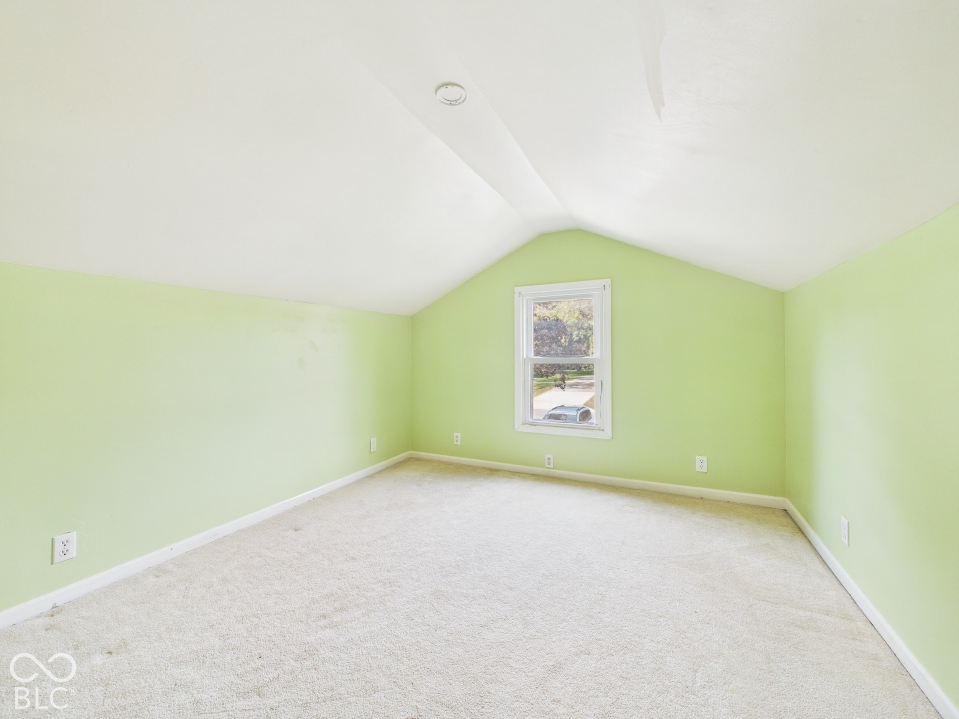 Sloped ceiling room featuring a single window and carpeted flooring