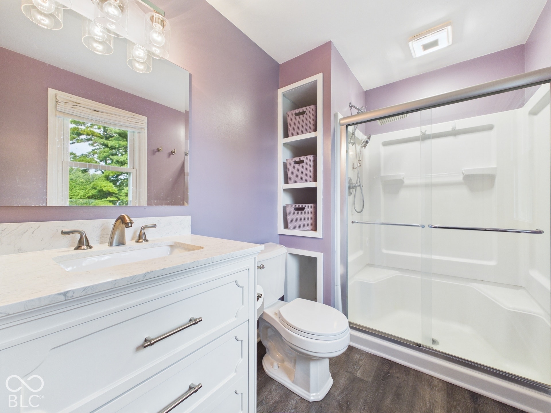 White vanity with brushed nickel hardware, integrated sink, and a white countertop