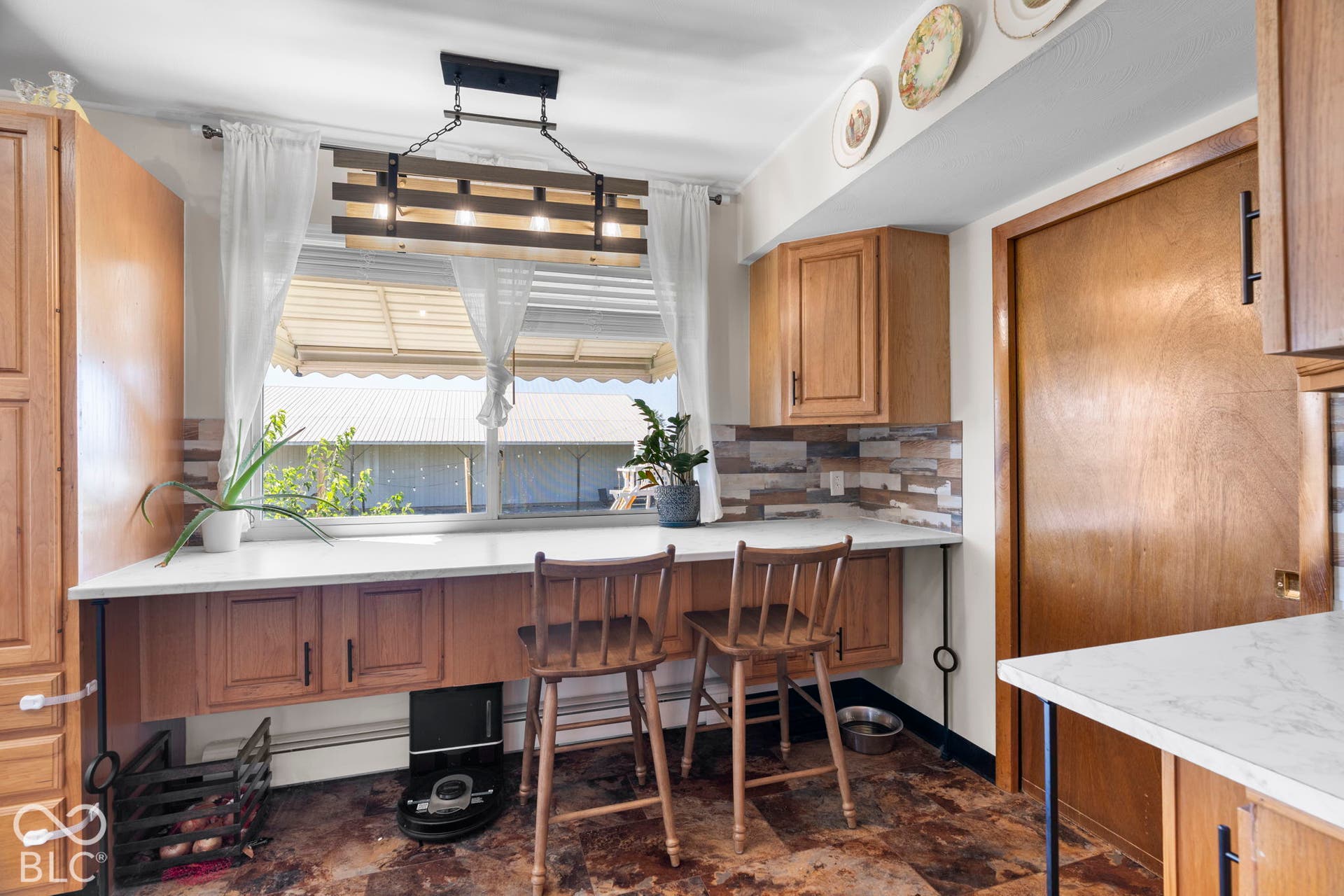 Eat-in kitchen featuring warm wood cabinetry, white quartz countertops, and a multi-seat island with turned spindle-back seating