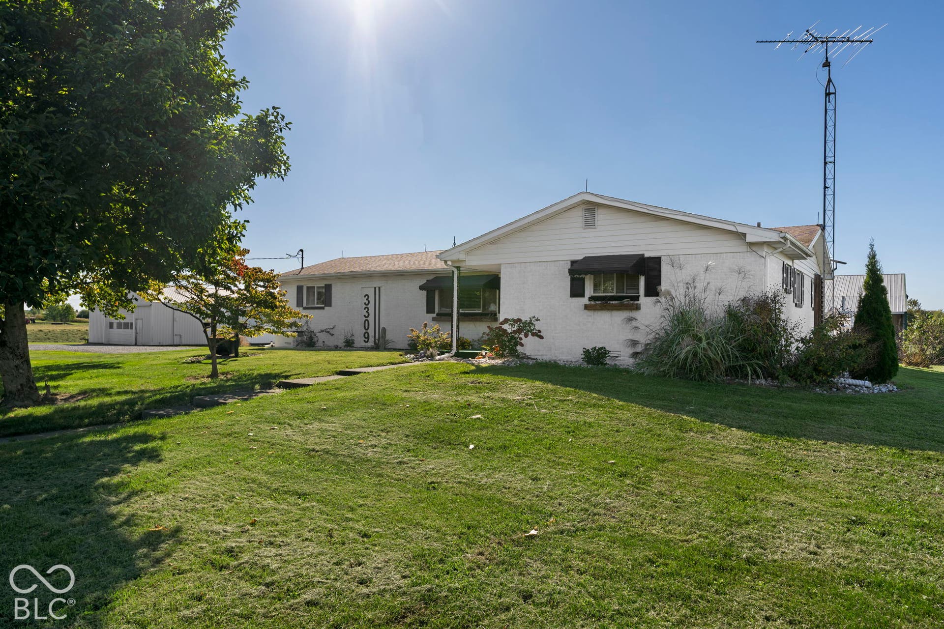 Spacious single-story residence set on expansive grounds with mature landscaping, including established trees and manicured lawn
