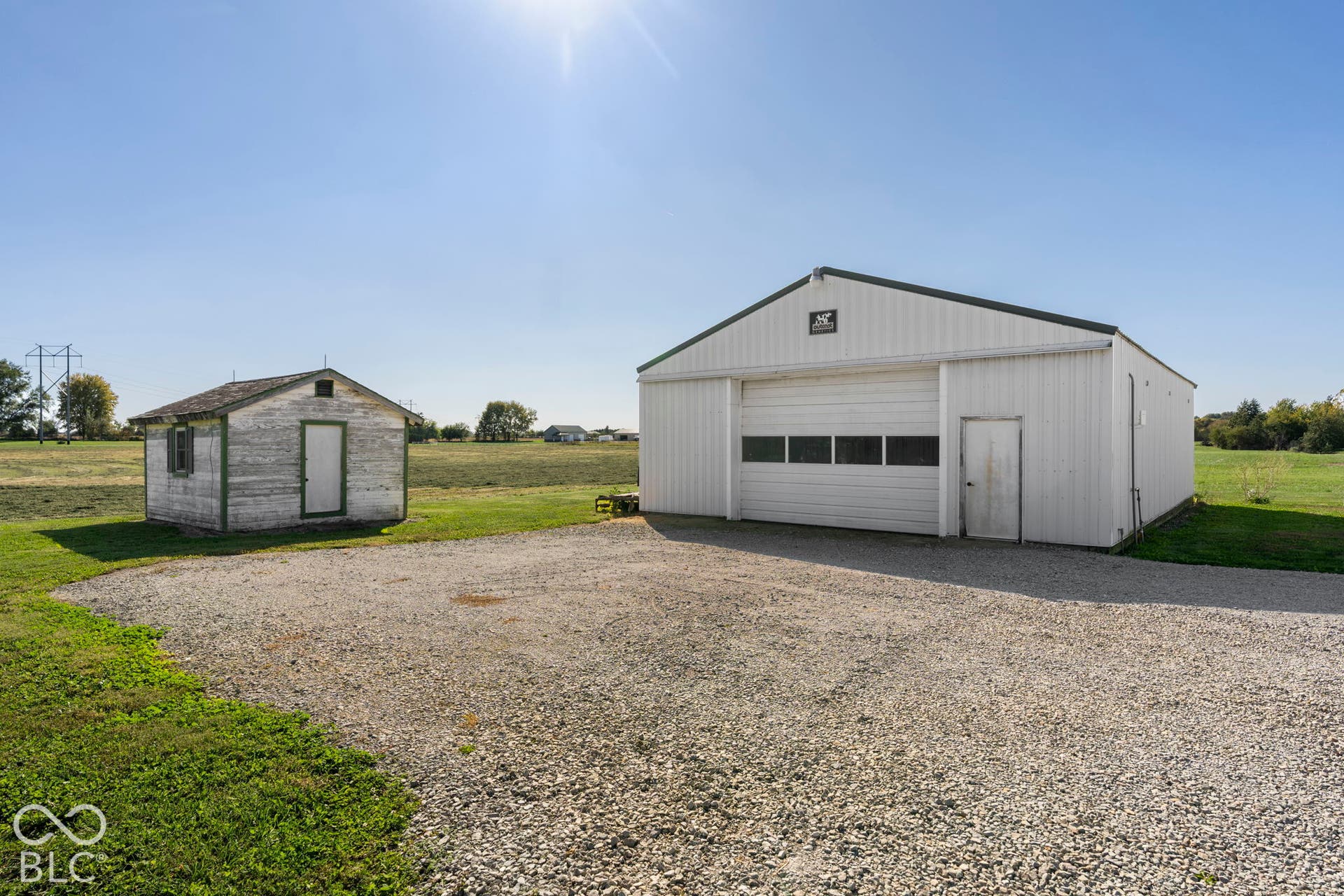 Spacious agricultural property featuring two metal-frame storage buildings with gable roofs