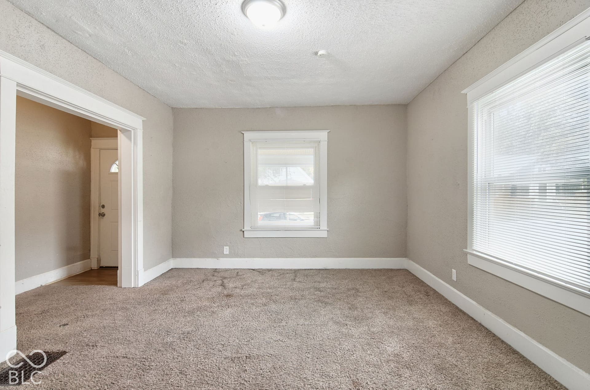Neutral wall paint, carpeted flooring, and bright overhead lighting