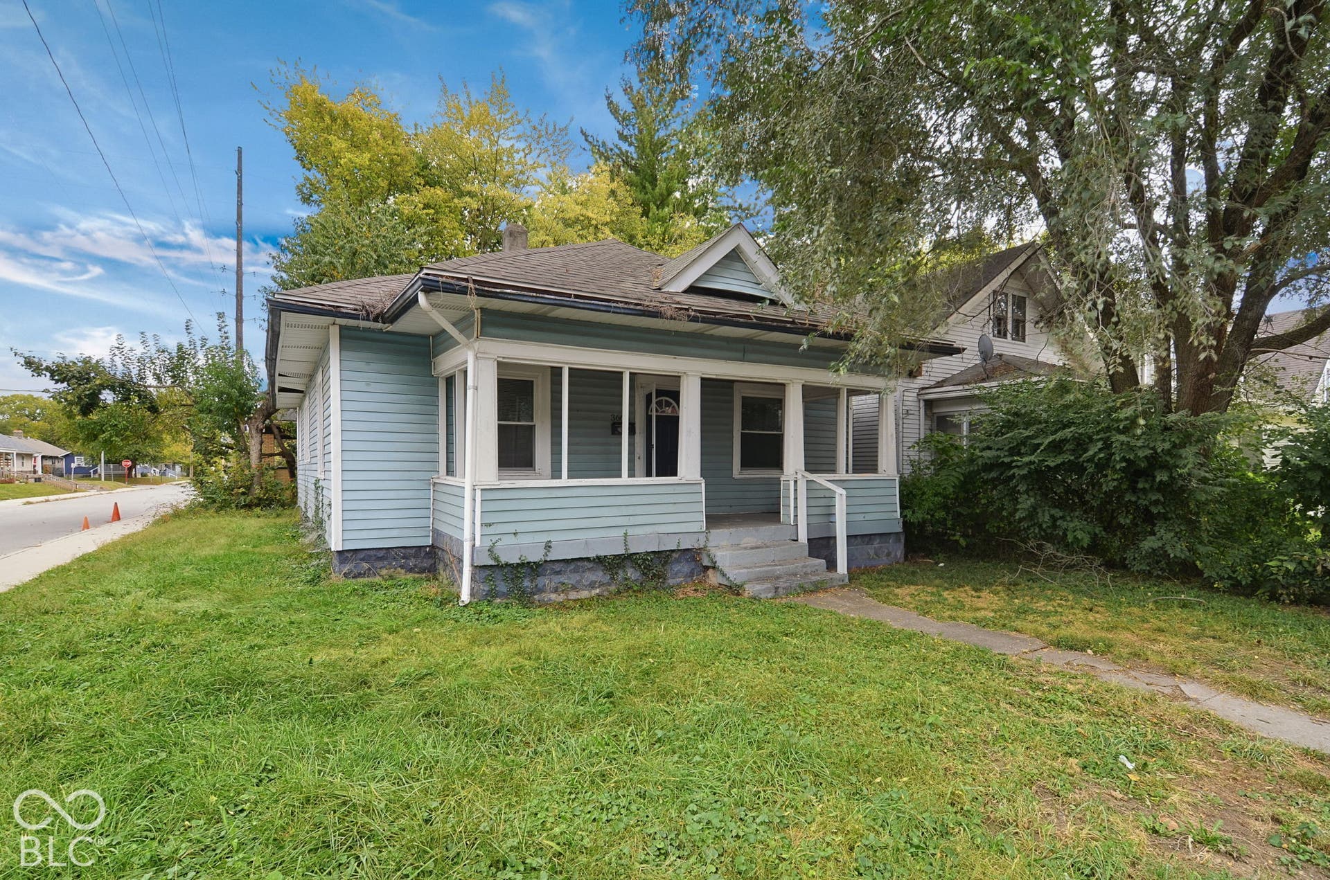 Front facade featuring light blue siding and a covered porch with white railings