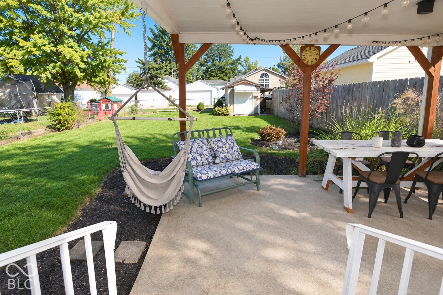 Covered patio featuring string lighting, wood posts, and concrete flooring