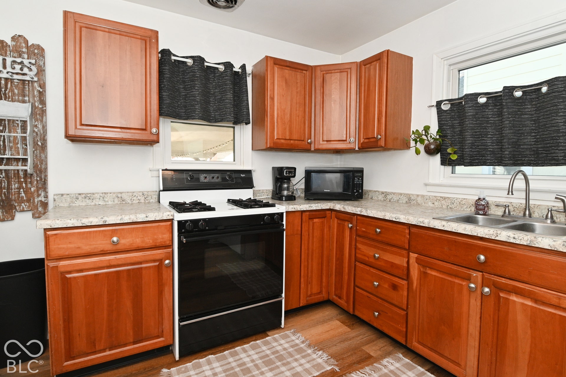 Warm wood cabinetry with brushed nickel hardware and ample storage throughout this galley-style kitchen