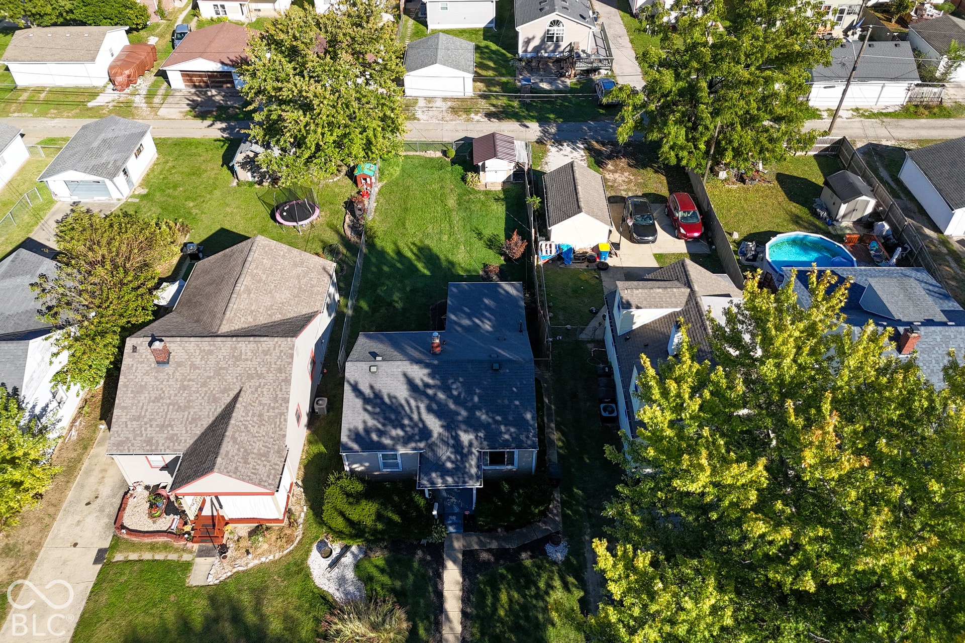 Gabled roofline, light-colored siding, and a paved driveway