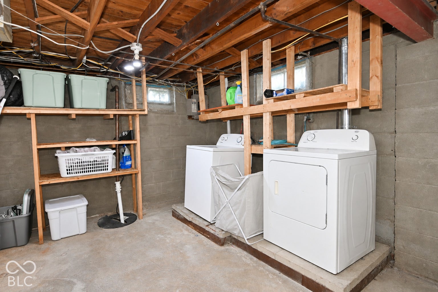 Exposed wood ceiling joists, concrete block walls, and a concrete floor