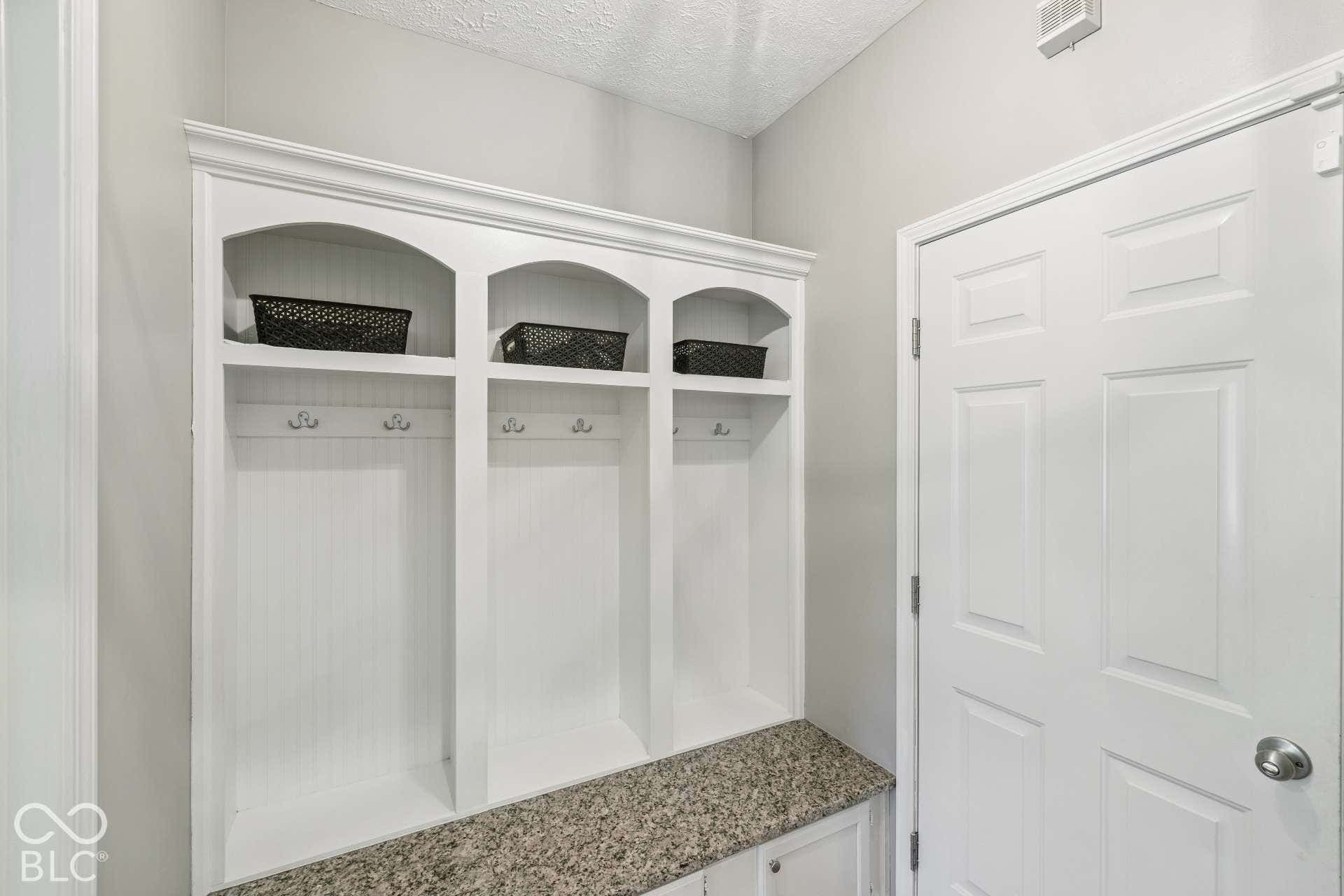 Dedicated mudroom with built-in cubbies creates a convenient drop zone for coats, shoes, backpacks and everyday necessities.