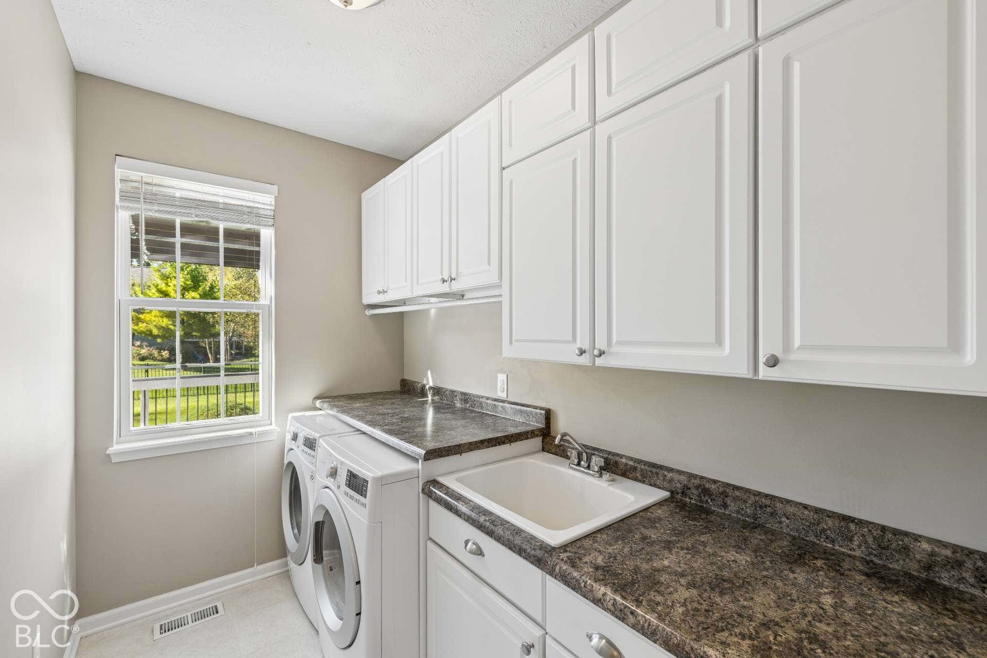 Separate laundry room offers extensive cabinetry, counter space and natural light for added everyday convenience.