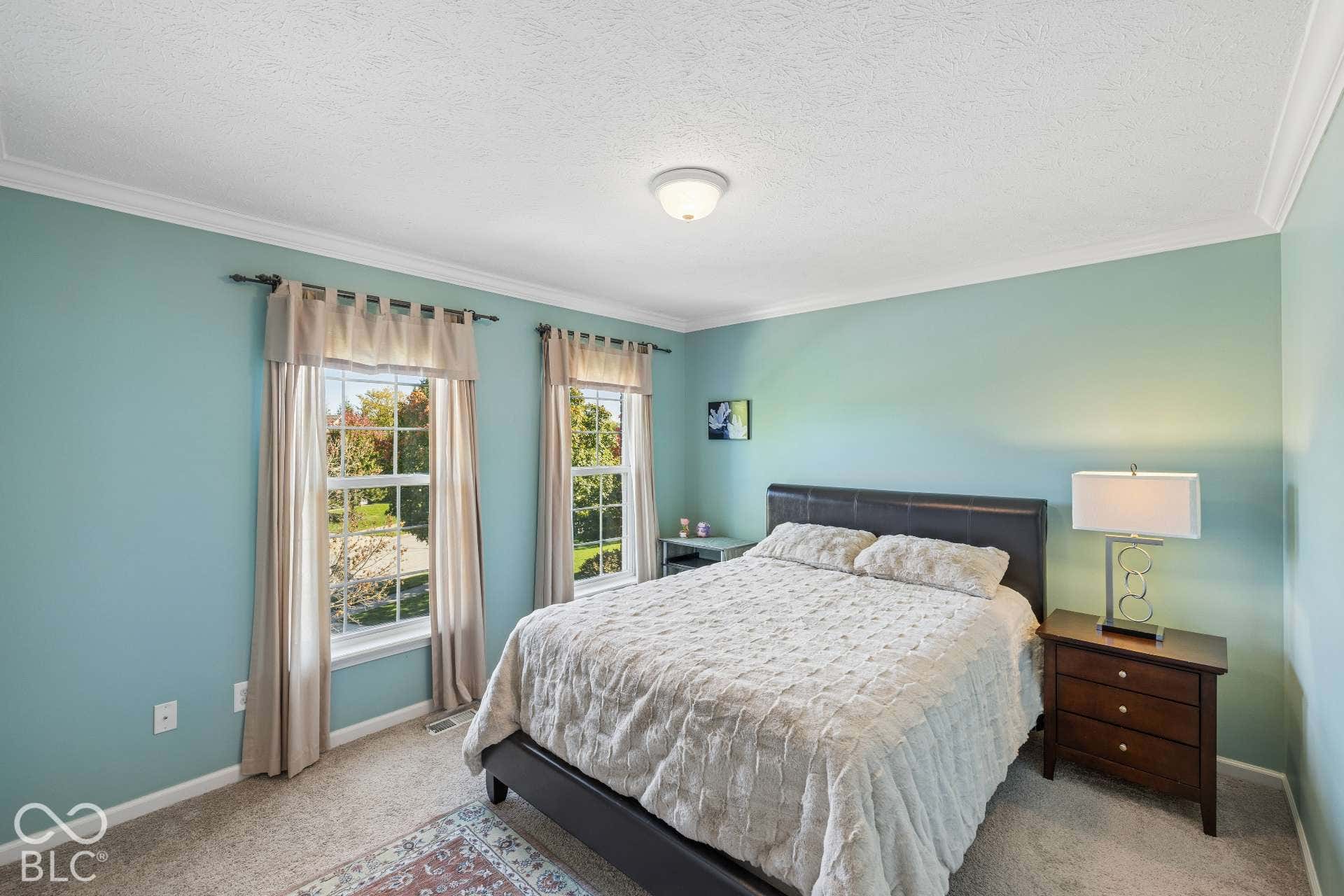 Comfortable secondary bedroom with abundant natural light and generous space for furniture.