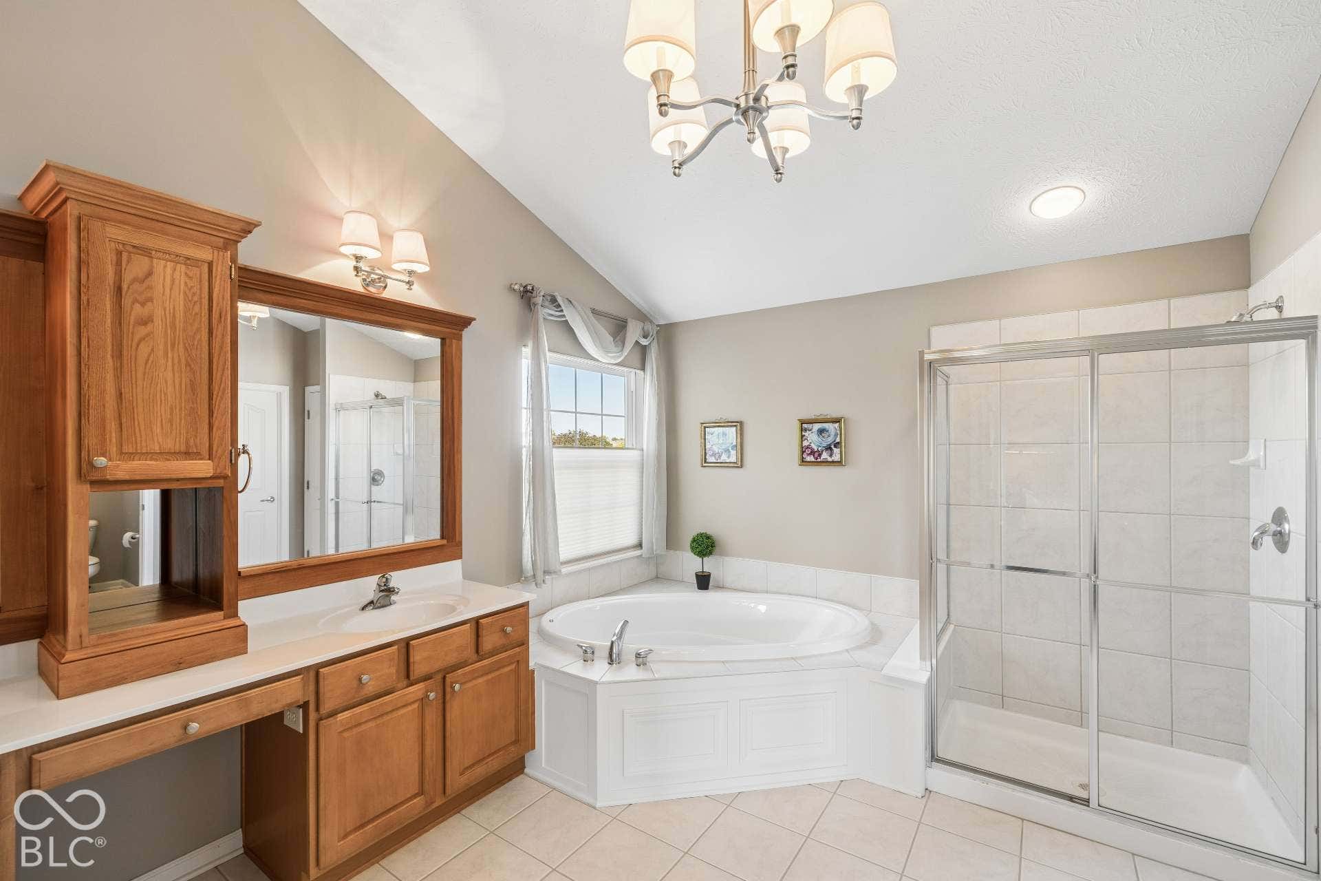 Spacious primary bath features dual vanities,garden tub and separate shower with plenty of cabinetry and counter space.