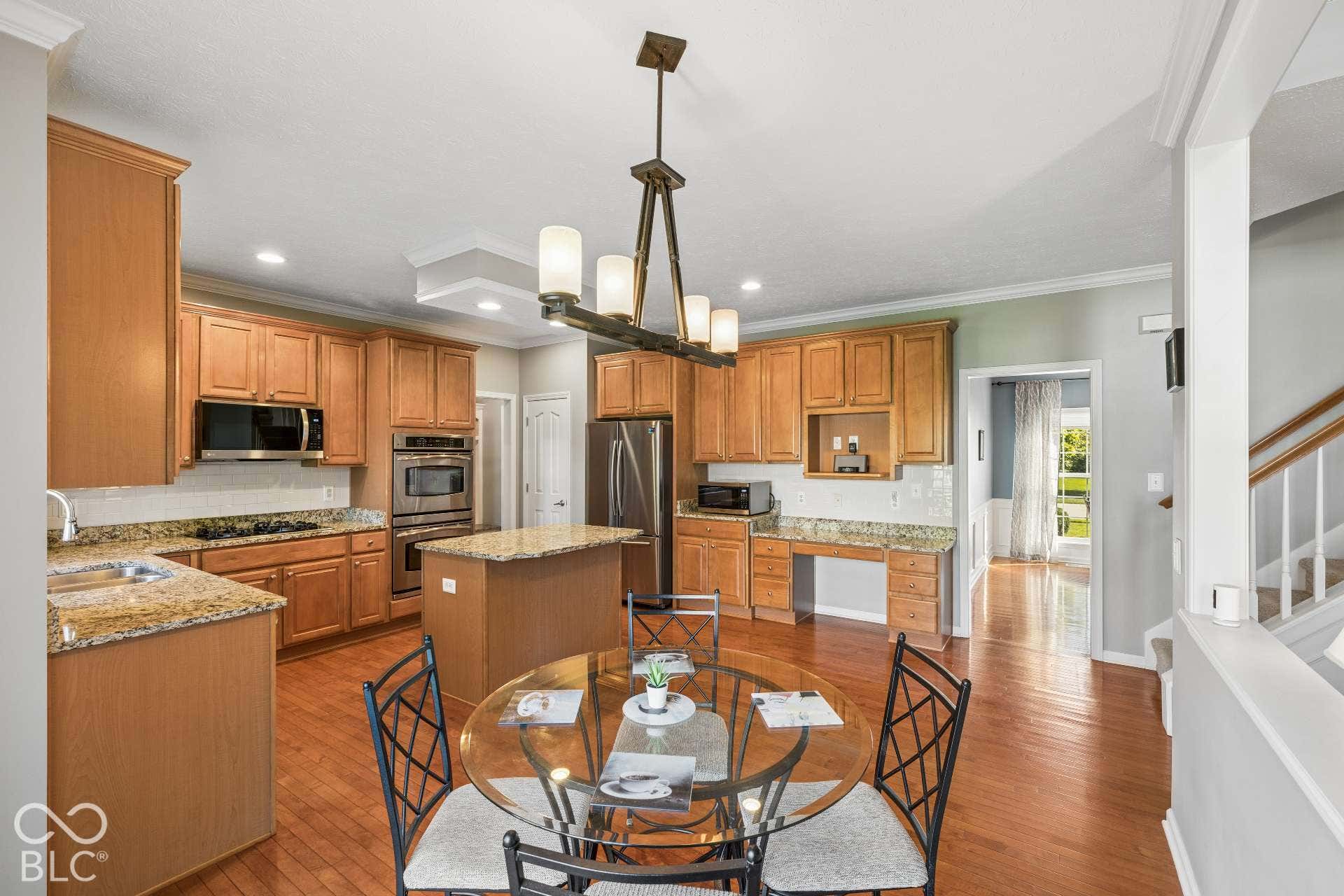 Open sightlines keep the kitchen connected to the breakfast area and surrounding living spaces with sliding glass doors leading to patio, pergola, and backyard.