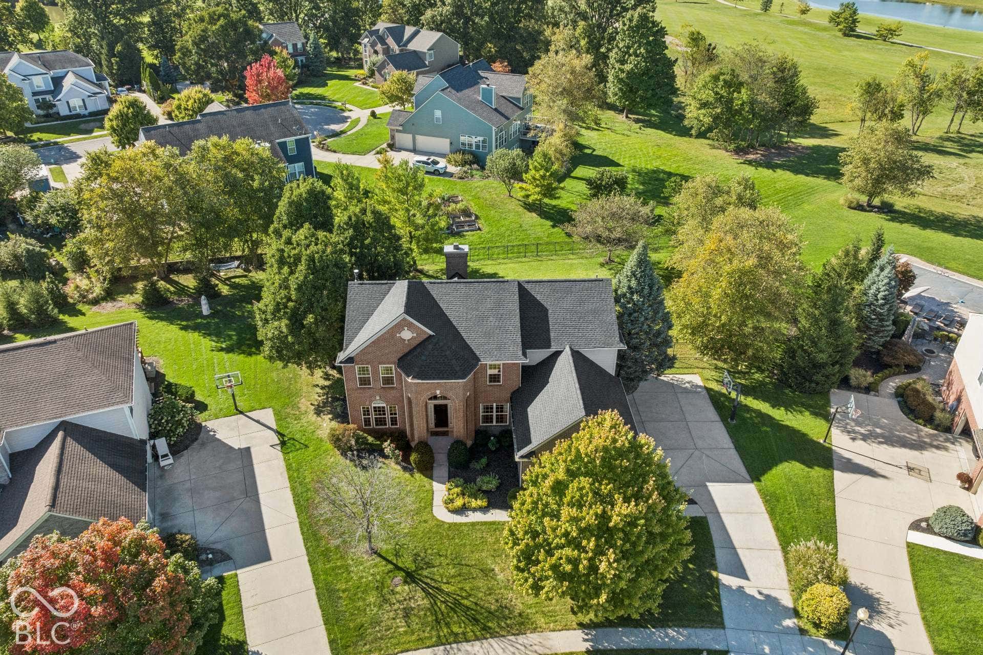 Aerial view showcases the home's beautiful private location along the golf course with mature landscaping and outdoor living spaces.