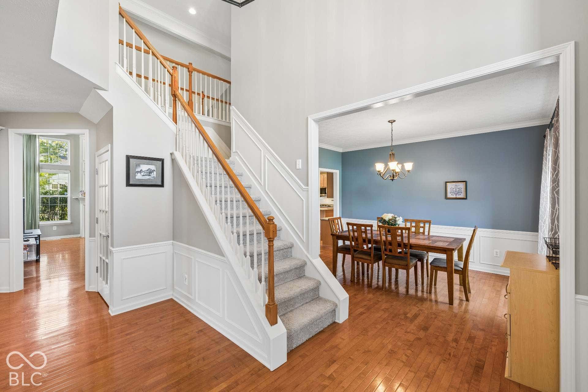 The entry opens to a spacious floor plan with hardwood floors and multiple living and entertaining spaces.