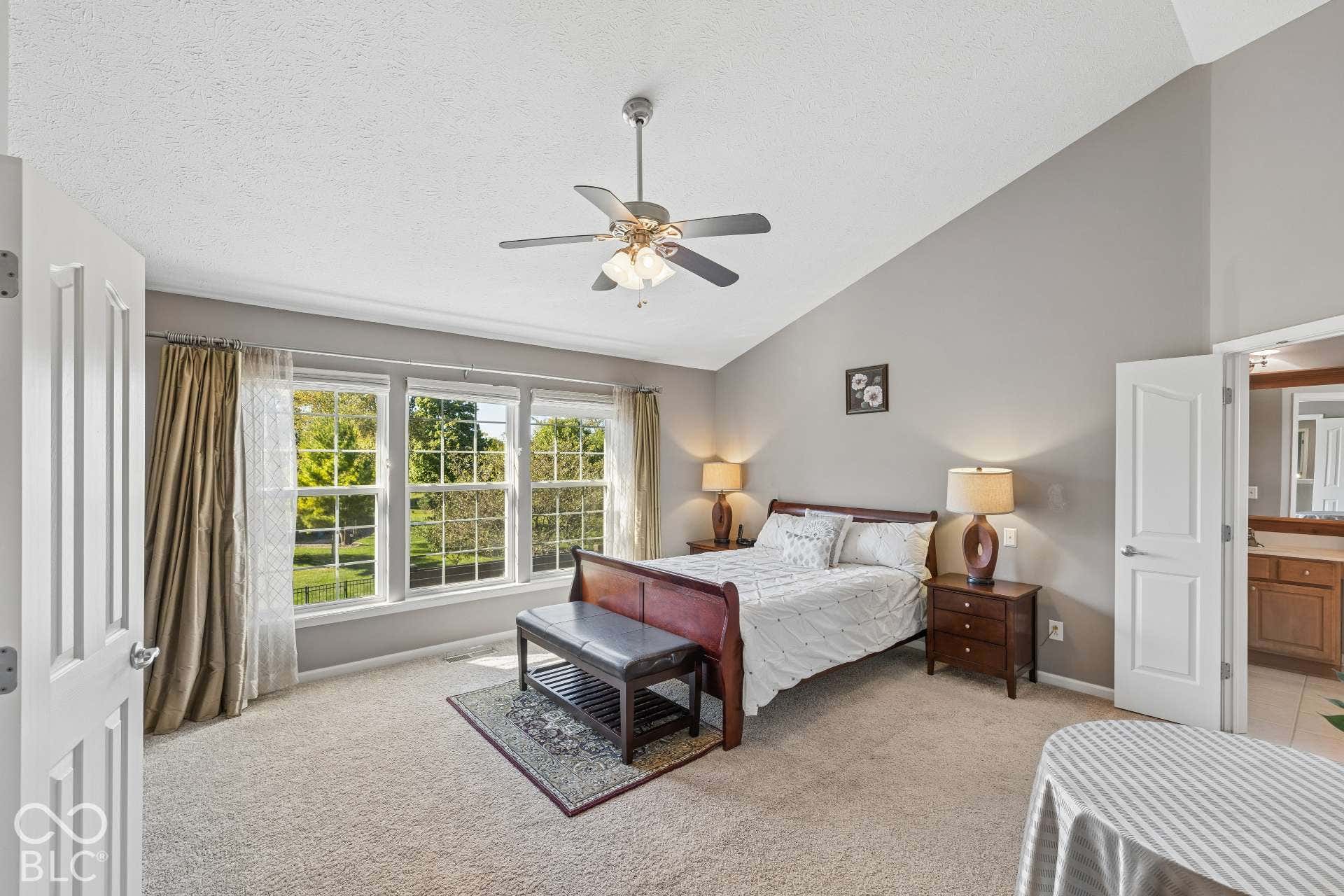 Spacious primary suite offers a relaxing retreat with a vaulted ceiling, abundant natural light and room for a sitting area.