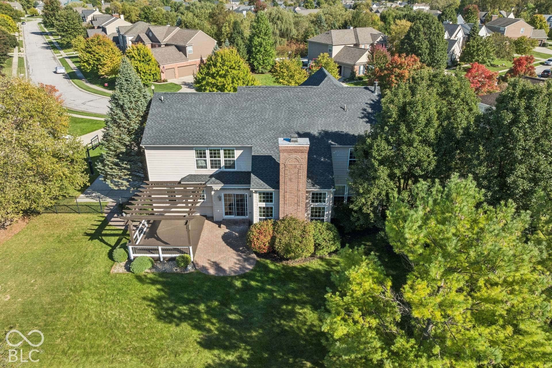 Aerial perspective highlights the home's location along the golf course and the mature trees surrounding the property.