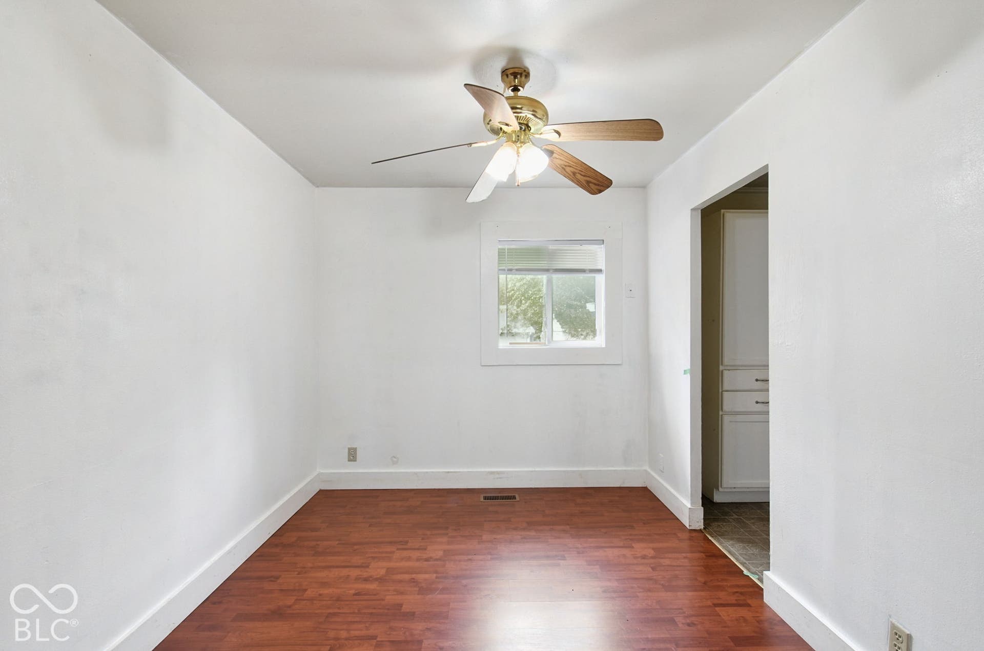 Recessed window with white trim, wood-finish flooring, ceiling fan with integrated lighting, and a neutral wall palette