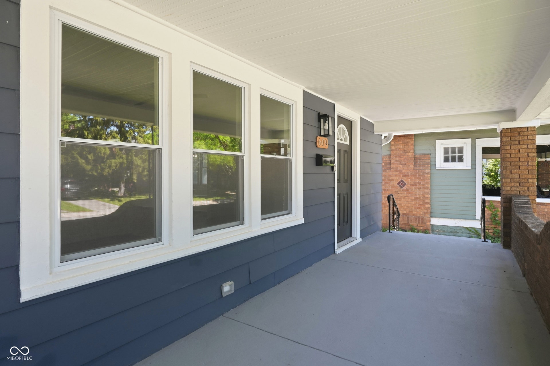 Covered concrete front porch featuring a dark gray painted surface