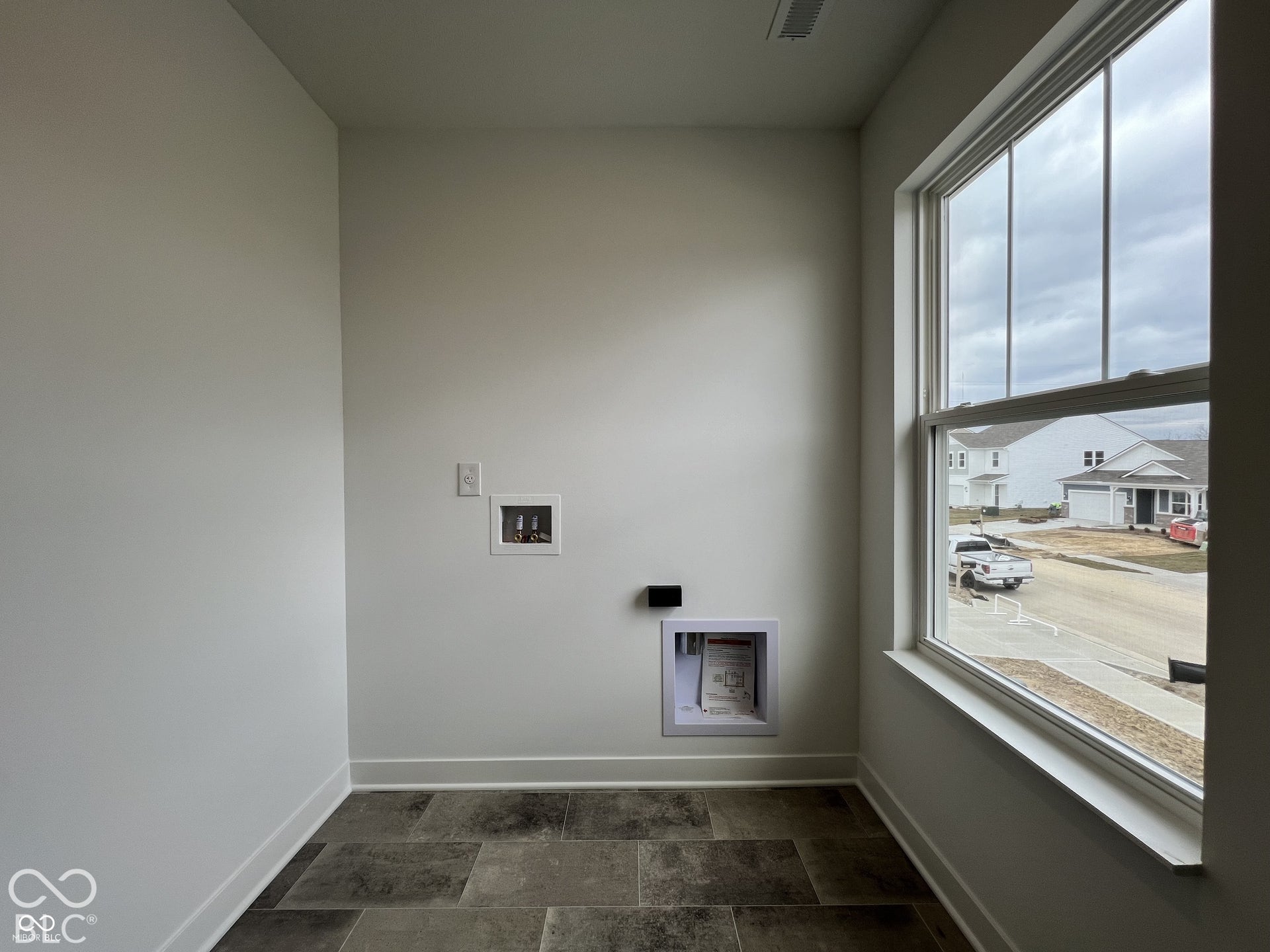 Large window, durable-finish flooring, white walls, built-in utility hookups, white trim