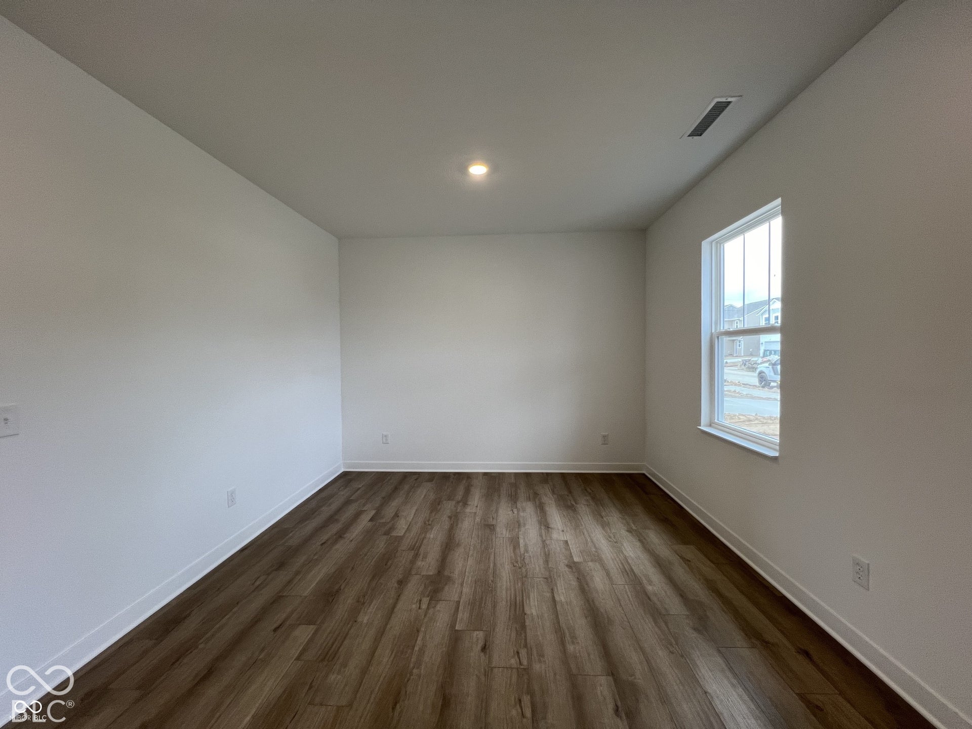 Recessed ceiling light, single pane window, wood-finish flooring, white walls