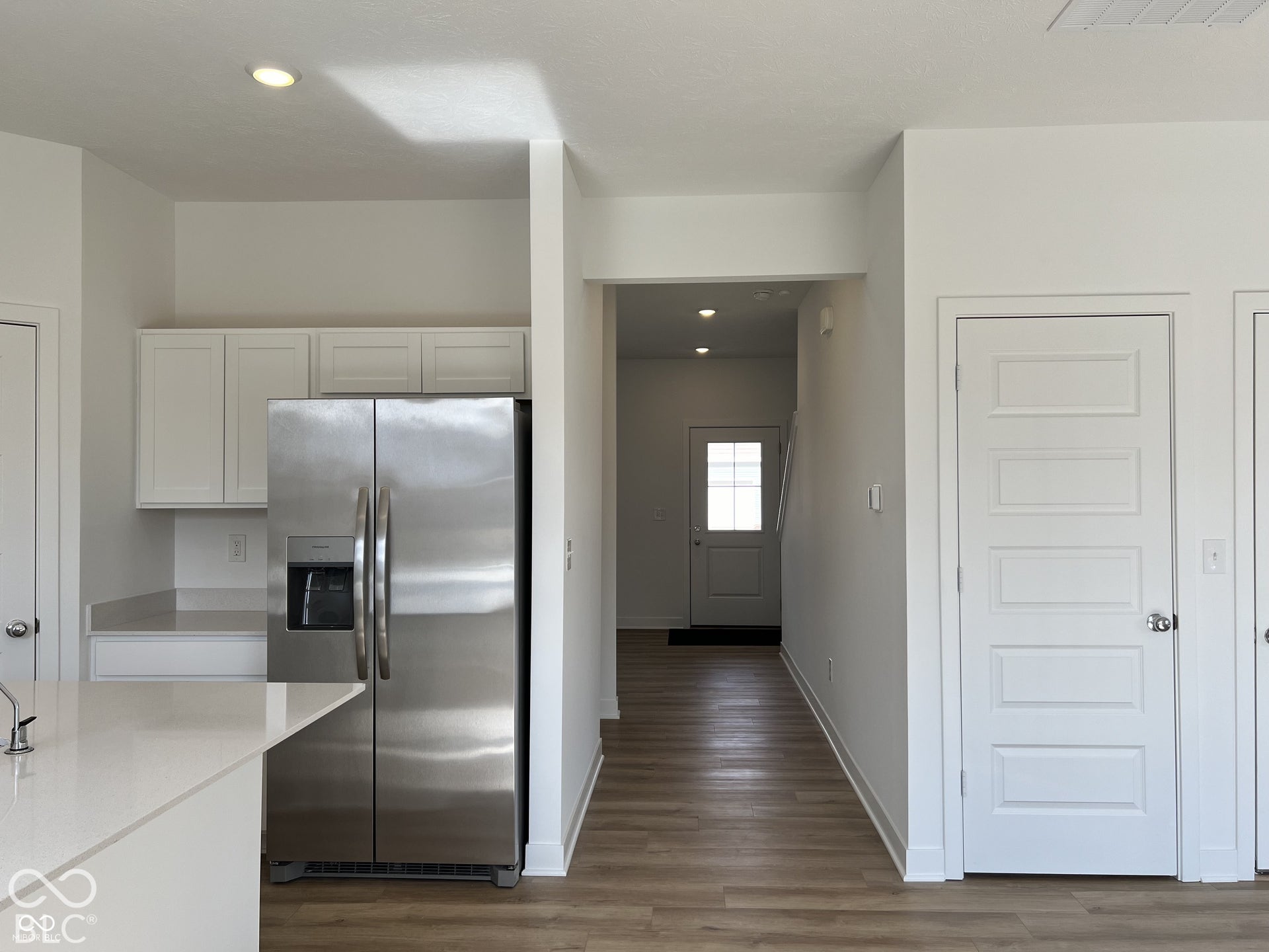 Kitchen featuring white cabinetry, light-toned countertops, and a stainless steel refrigerator