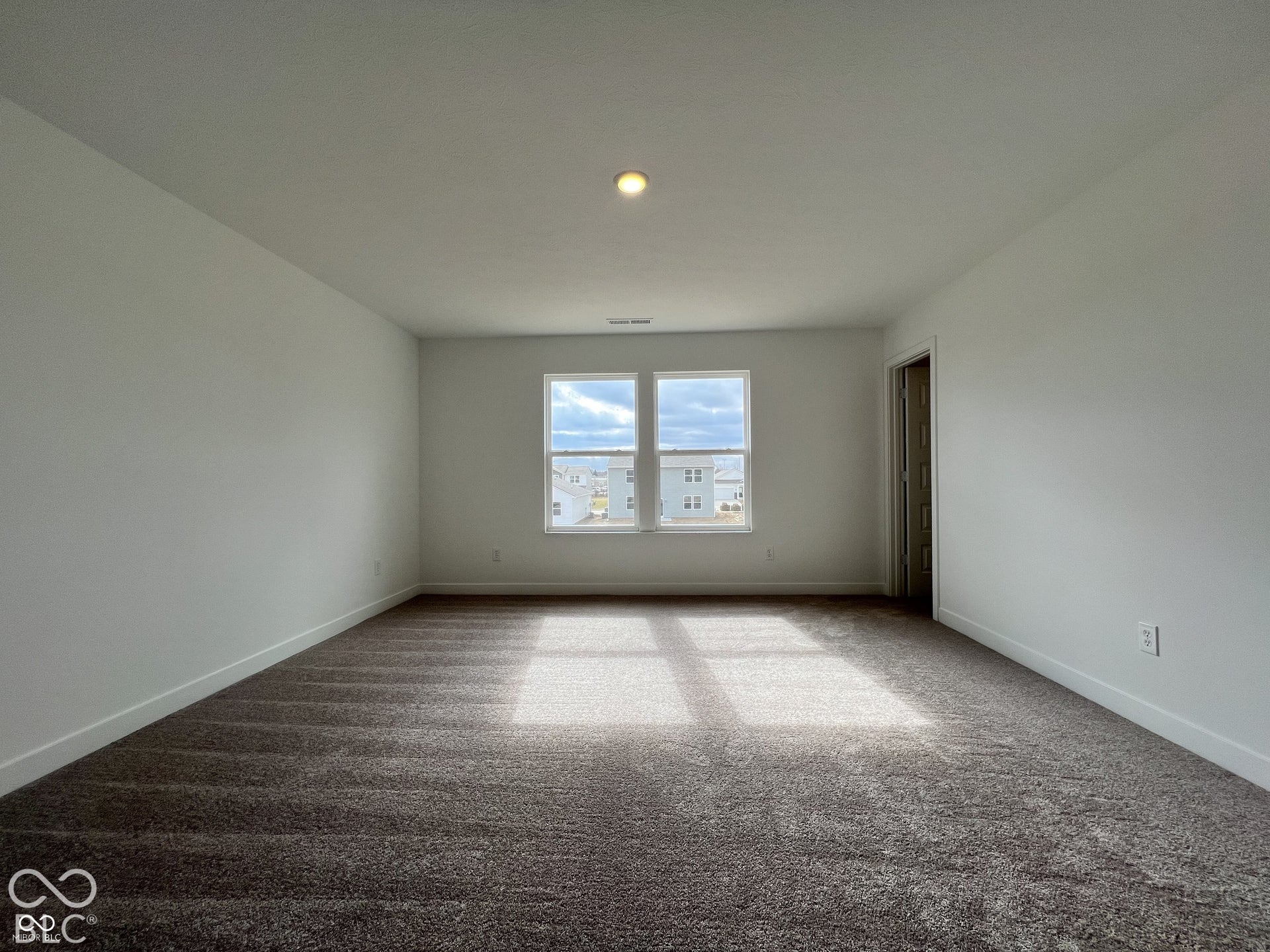 Spacious room with a neutral color palette, recessed lighting, and carpet flooring
