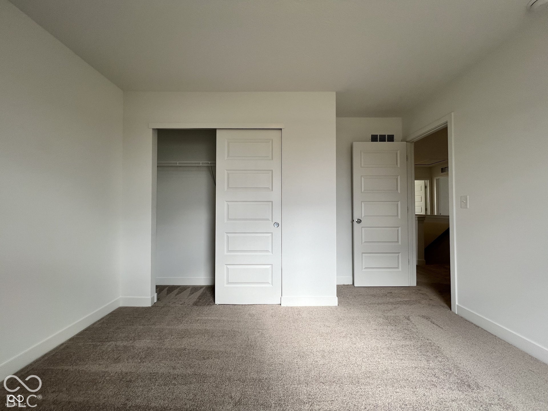 Neutral-toned carpeting, white walls, and white trim