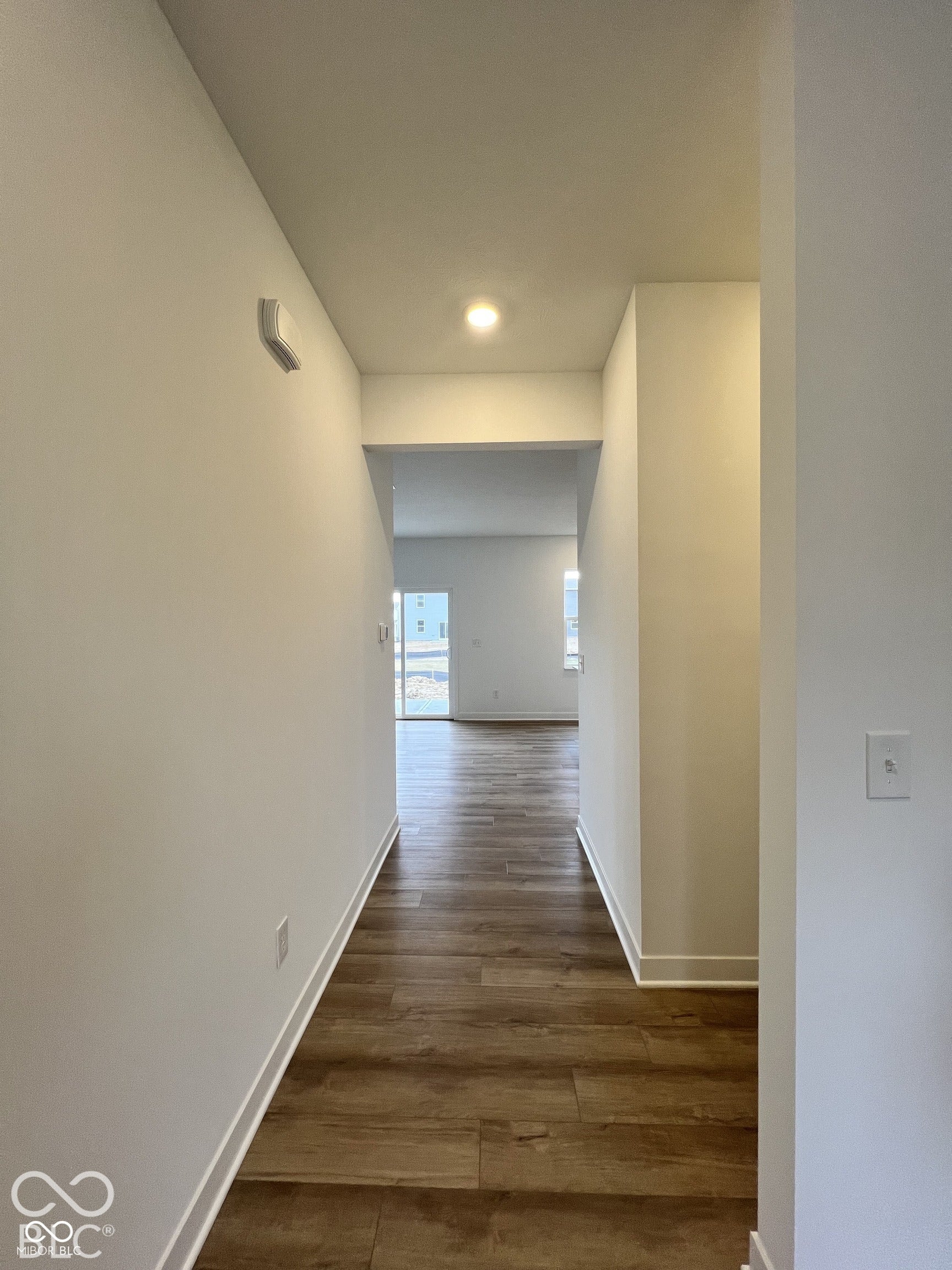 Wood-finish flooring throughout, recessed ceiling light, and neutral wall tones