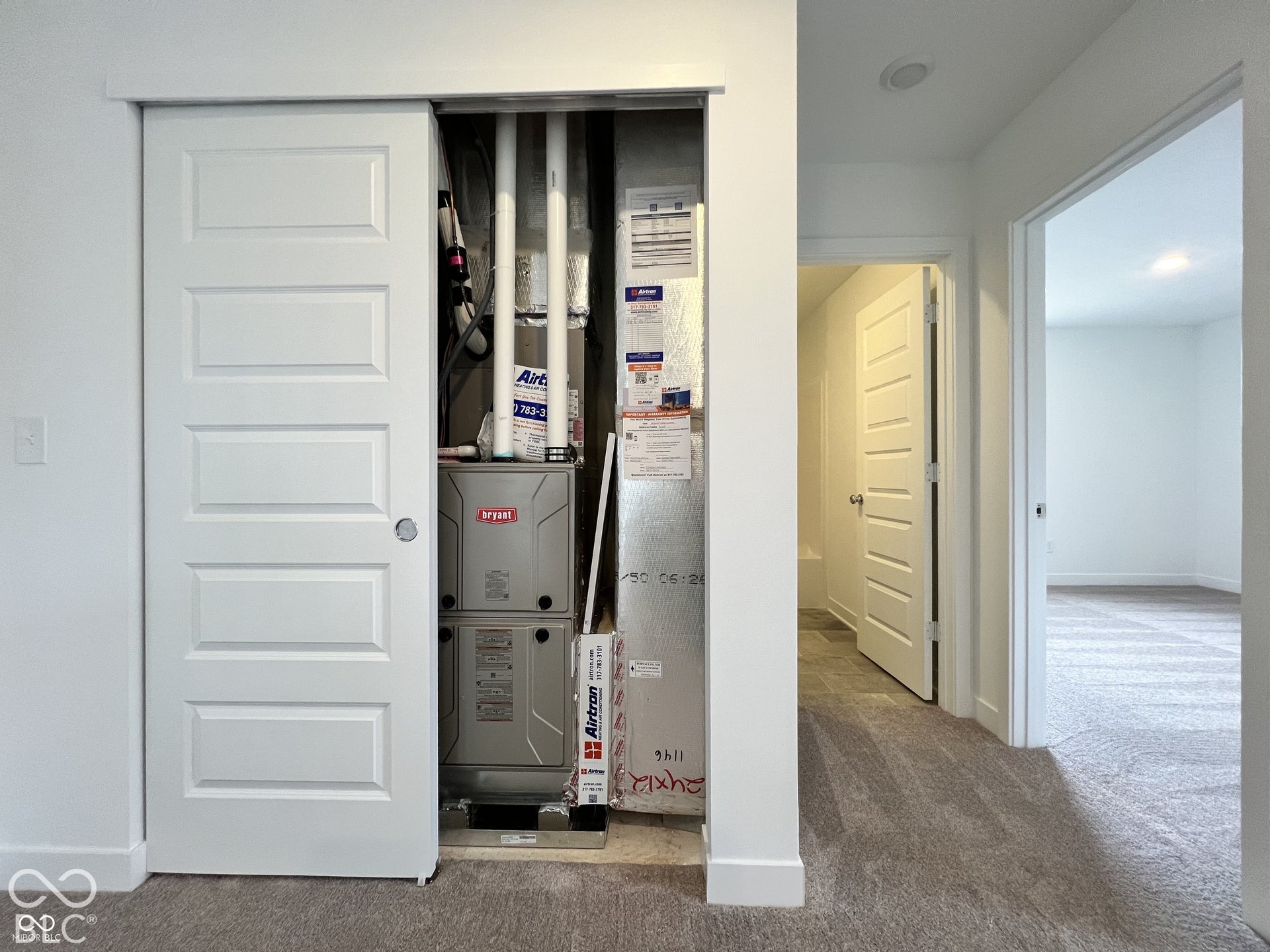 Sliding paneled door concealing a utility closet with HVAC equipment