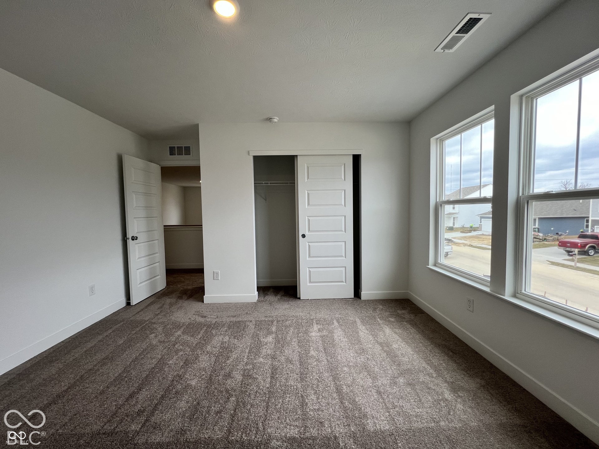Neutral tone carpet flooring, recessed lighting, and multiple windows