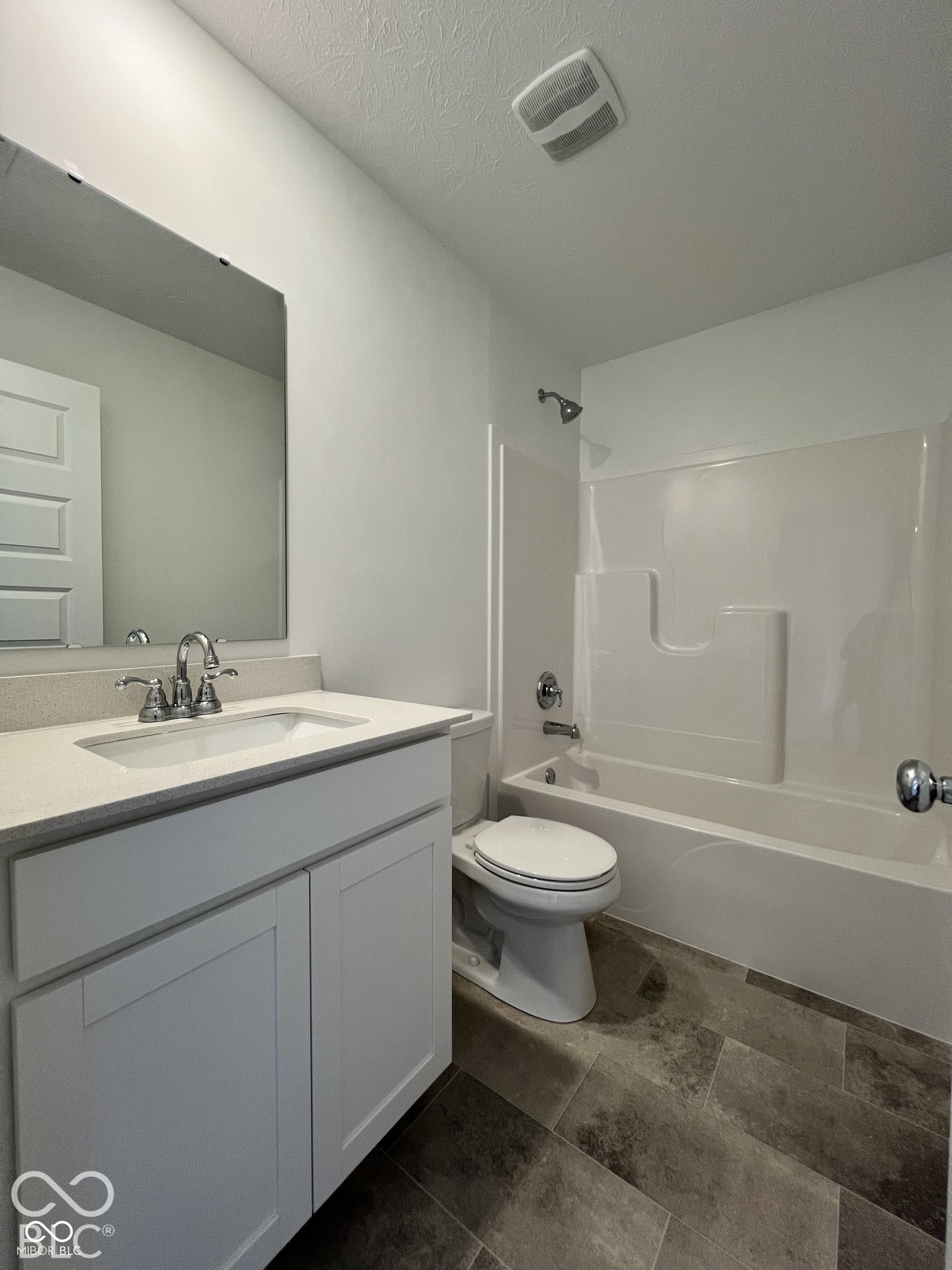 White shaker-style vanity with a light-toned countertop, undermount sink, and polished chrome faucet