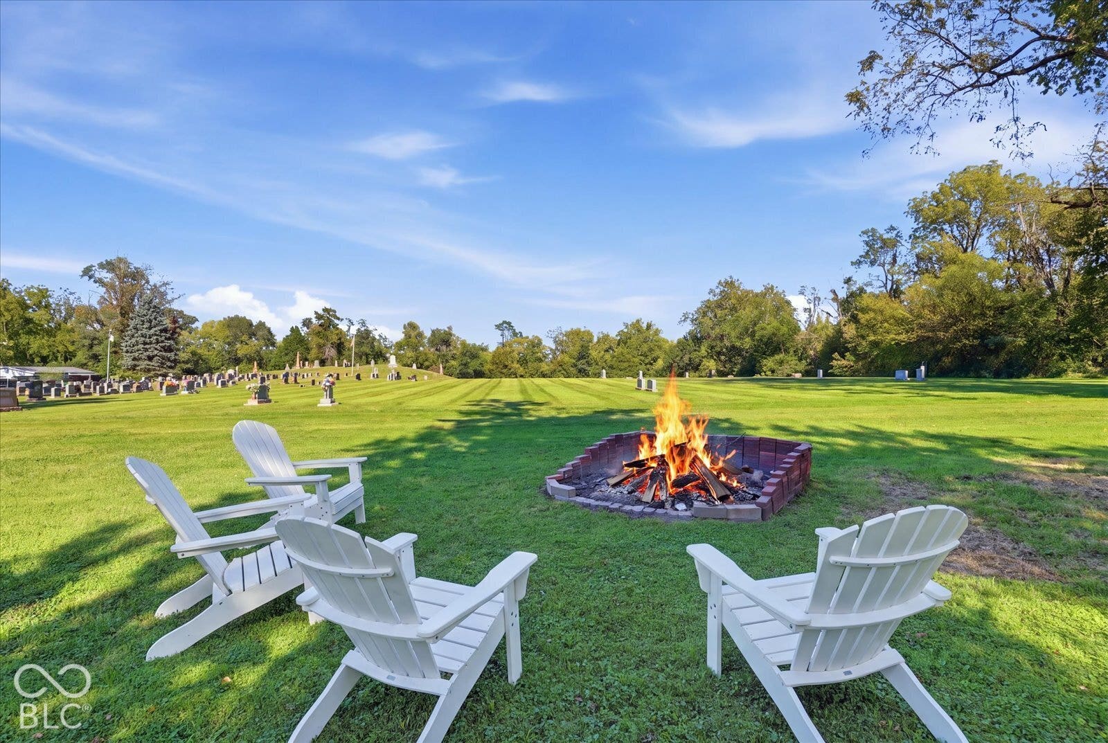 Virtually Altered - Expansive lawn area featuring a built-in fire pit with a brick surround