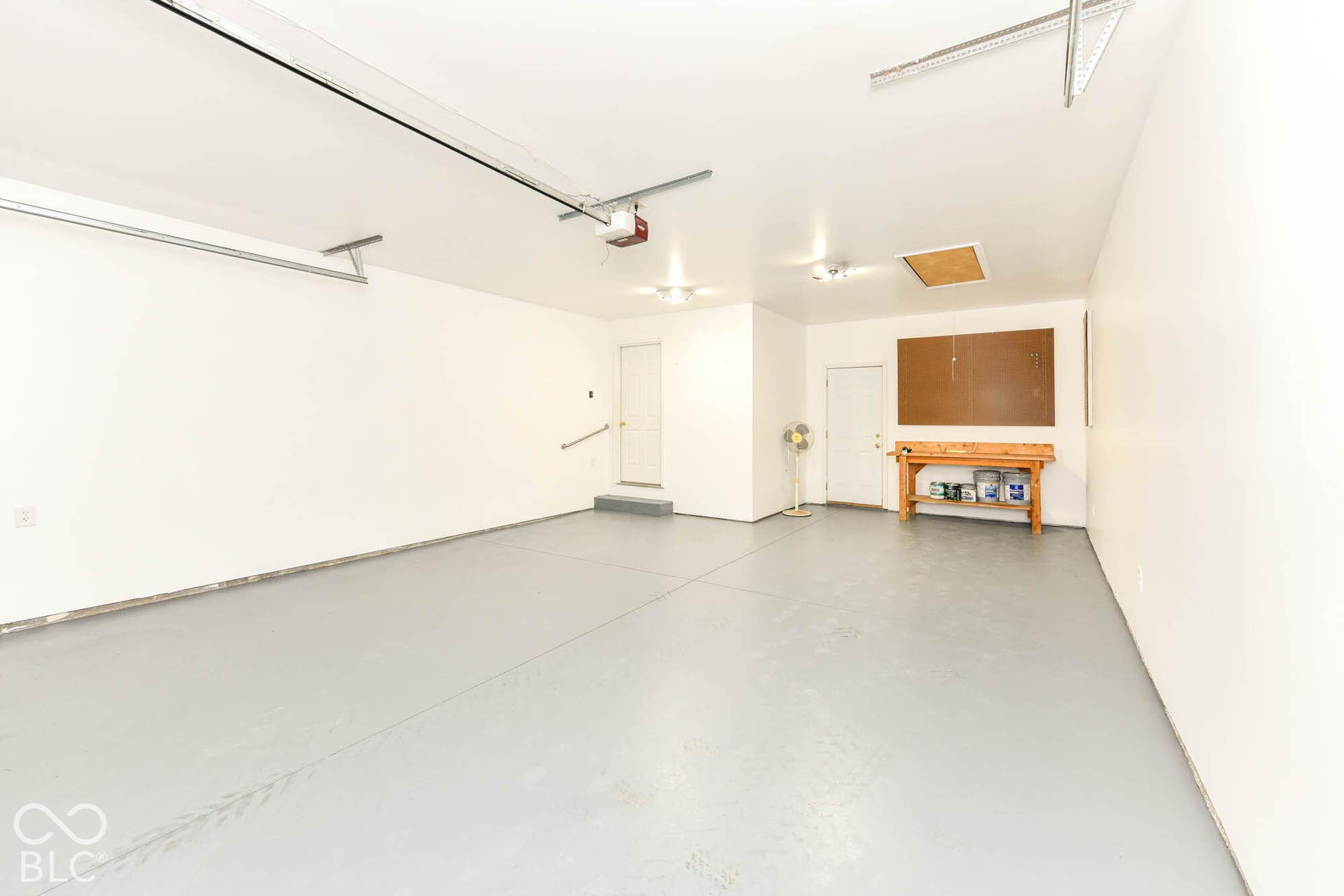 Expansive garage featuring a light gray floor, white walls, and bright overhead lighting