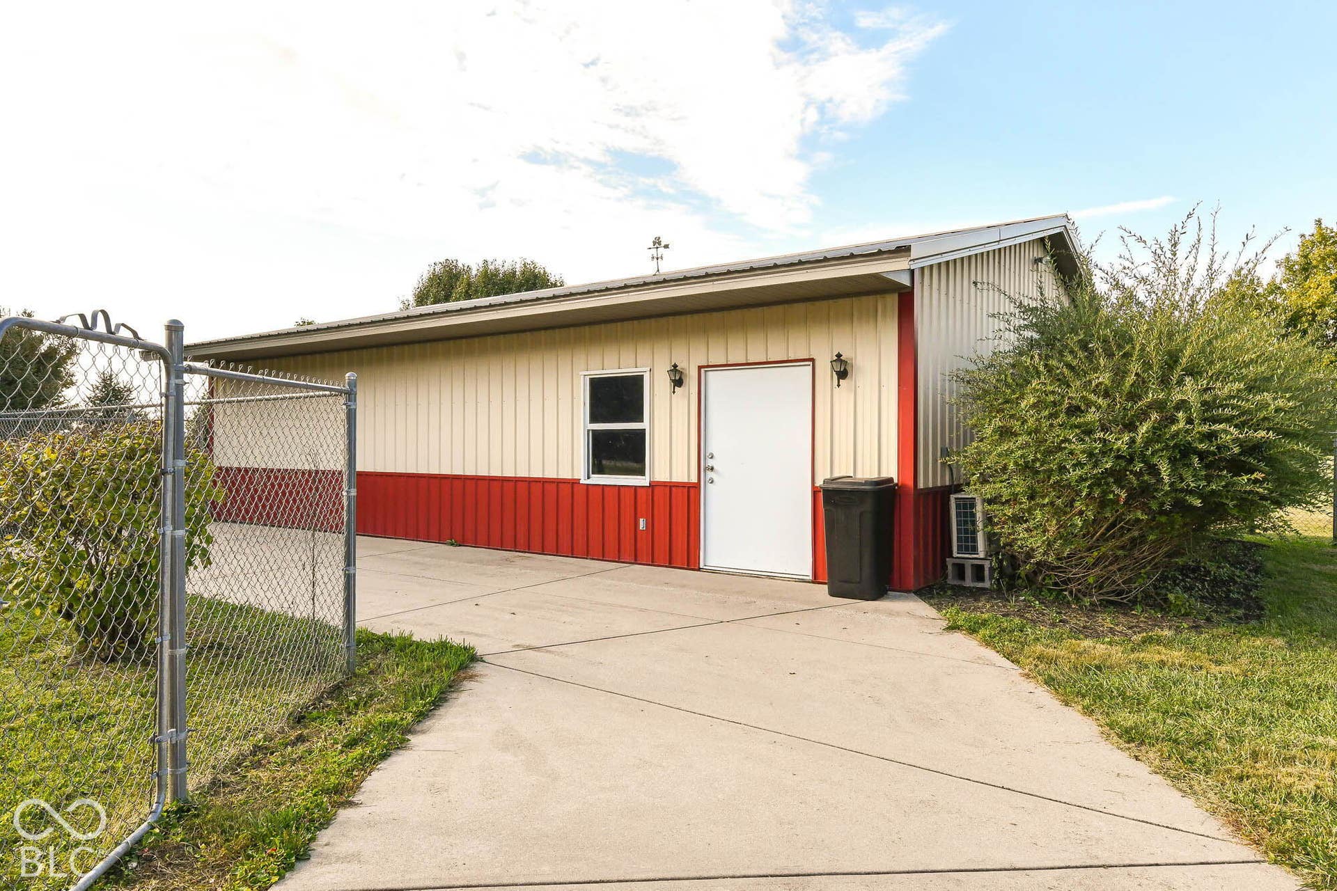 Metal-sided building featuring a two-tone exterior and a concrete driveway