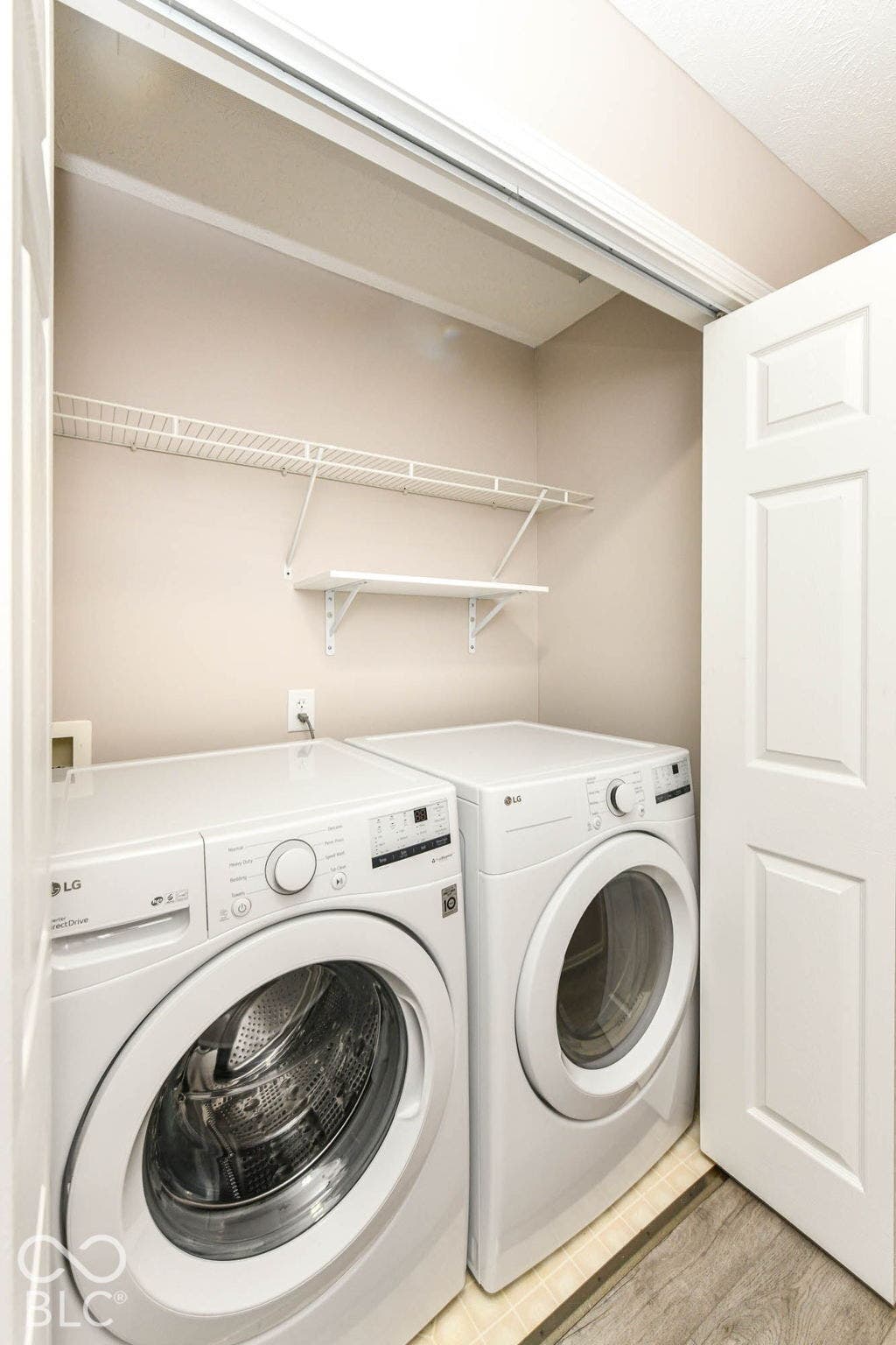Dedicated laundry area with a white front-loading washer and dryer set