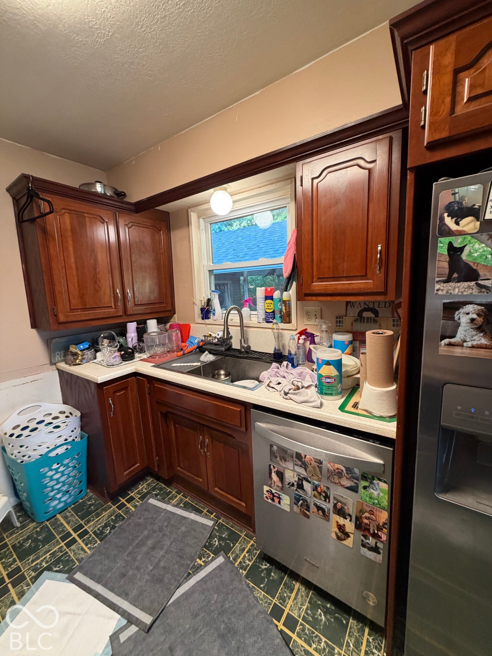 Wood-finish cabinetry, stainless steel dishwasher, and a double-basin sink