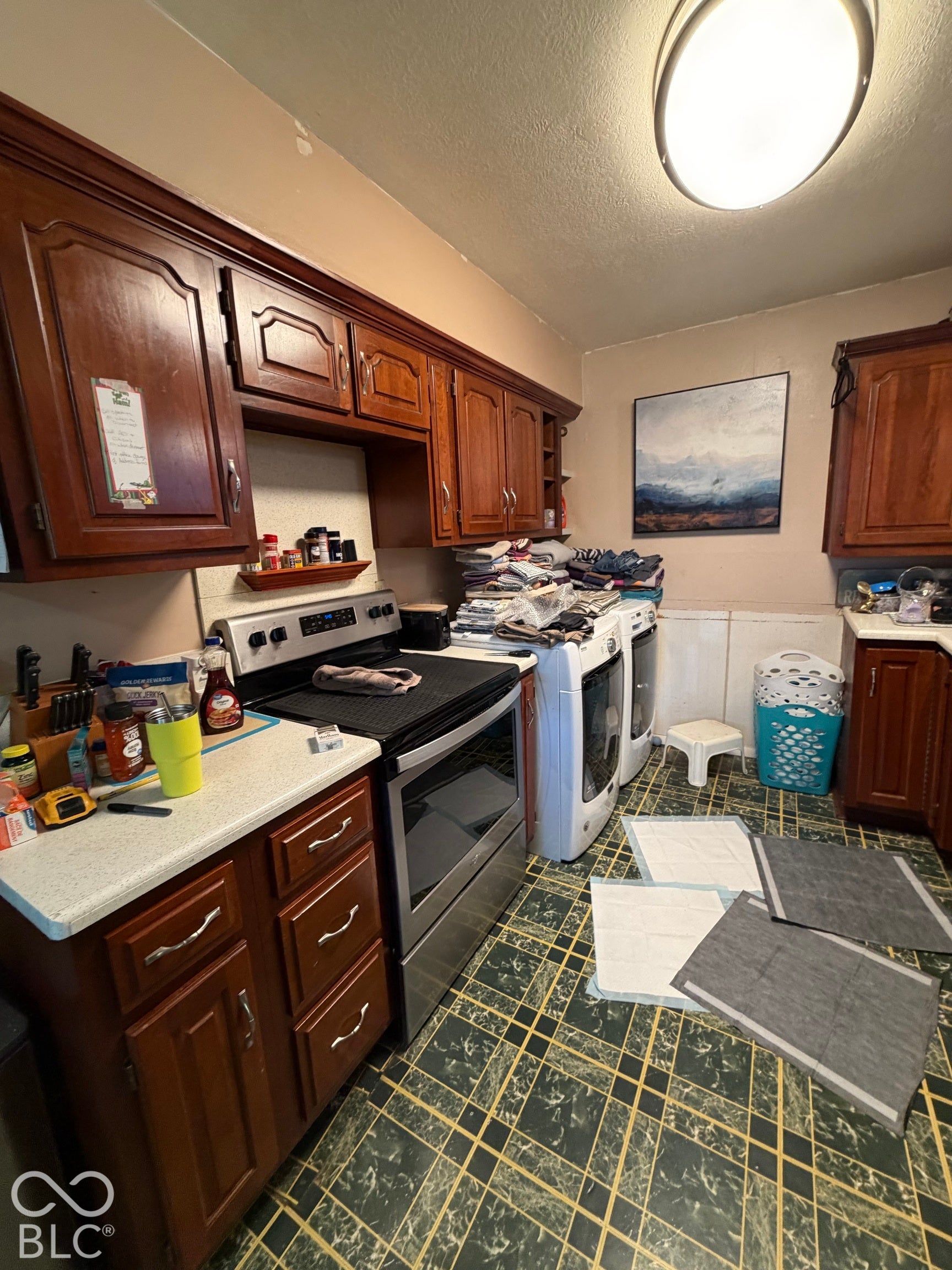 Wood-finish cabinetry with silver-tone hardware, white countertops, and a built-in range