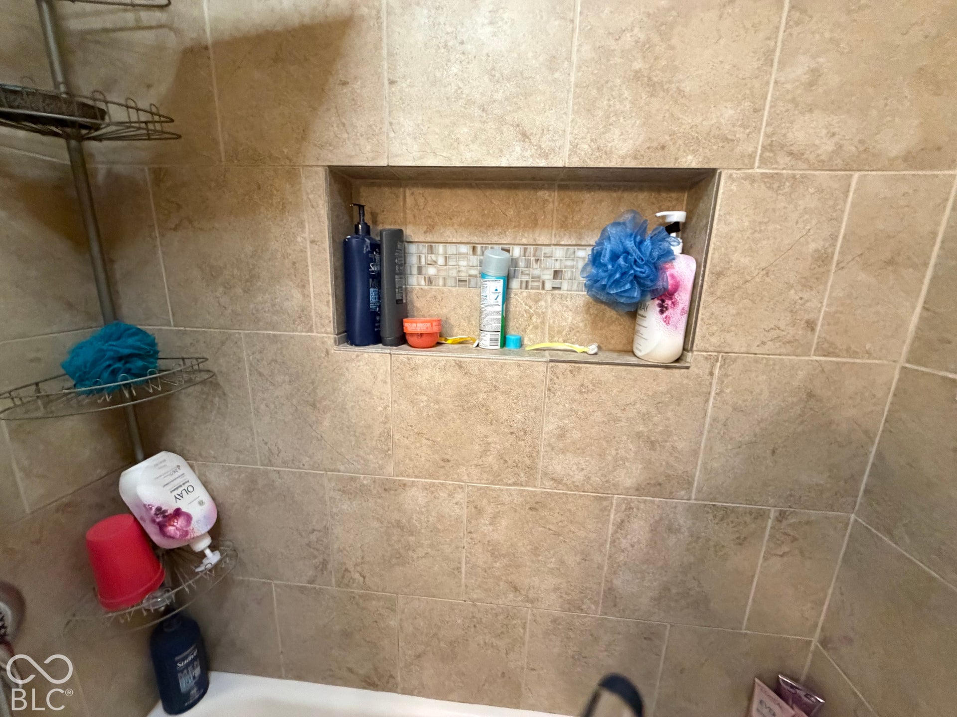 Tiled shower surround with an integrated shower niche featuring mosaic tile