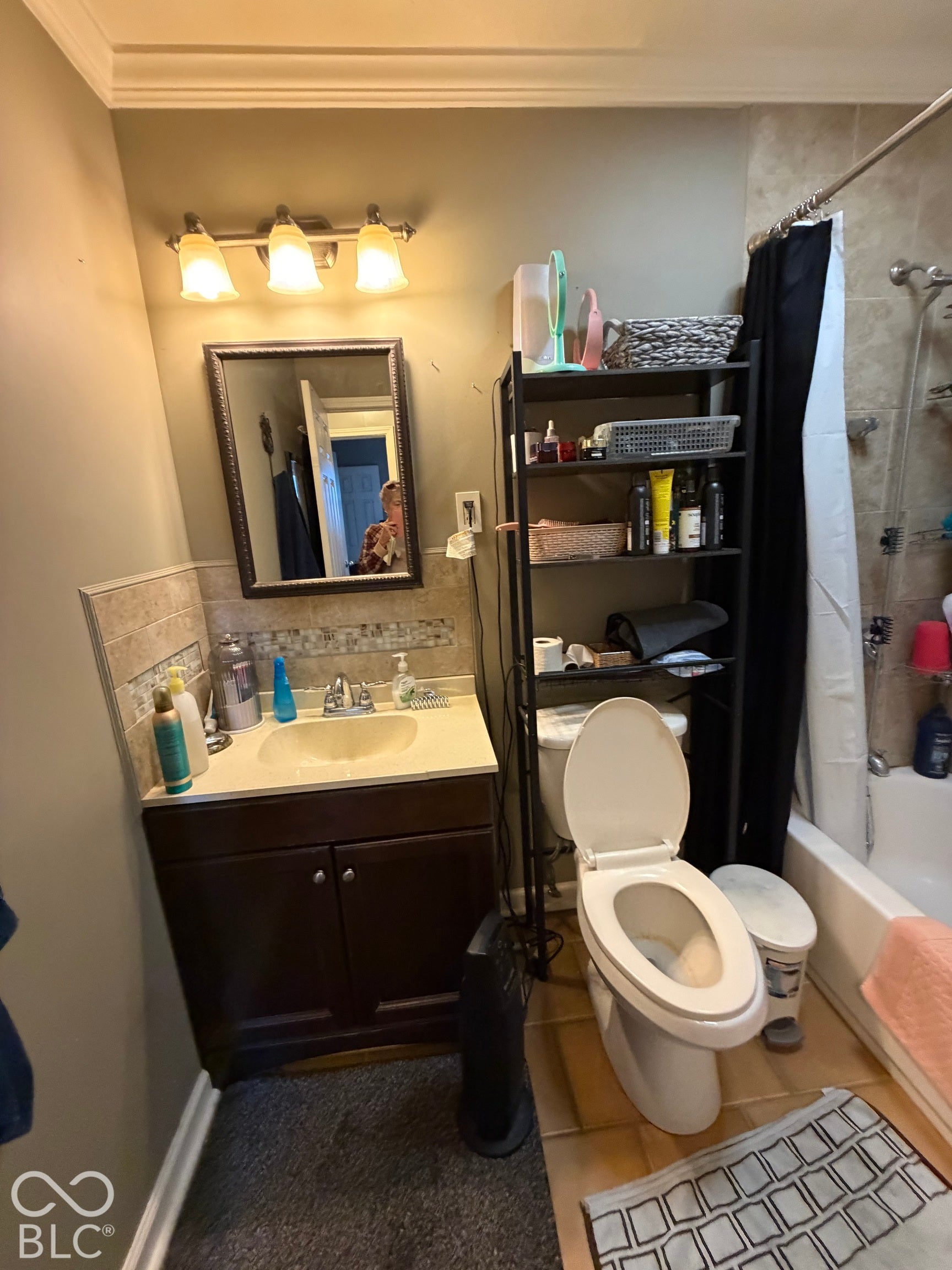 Dark wood-finish vanity with a built-in sink, brushed nickel faucet, and a tiled backsplash