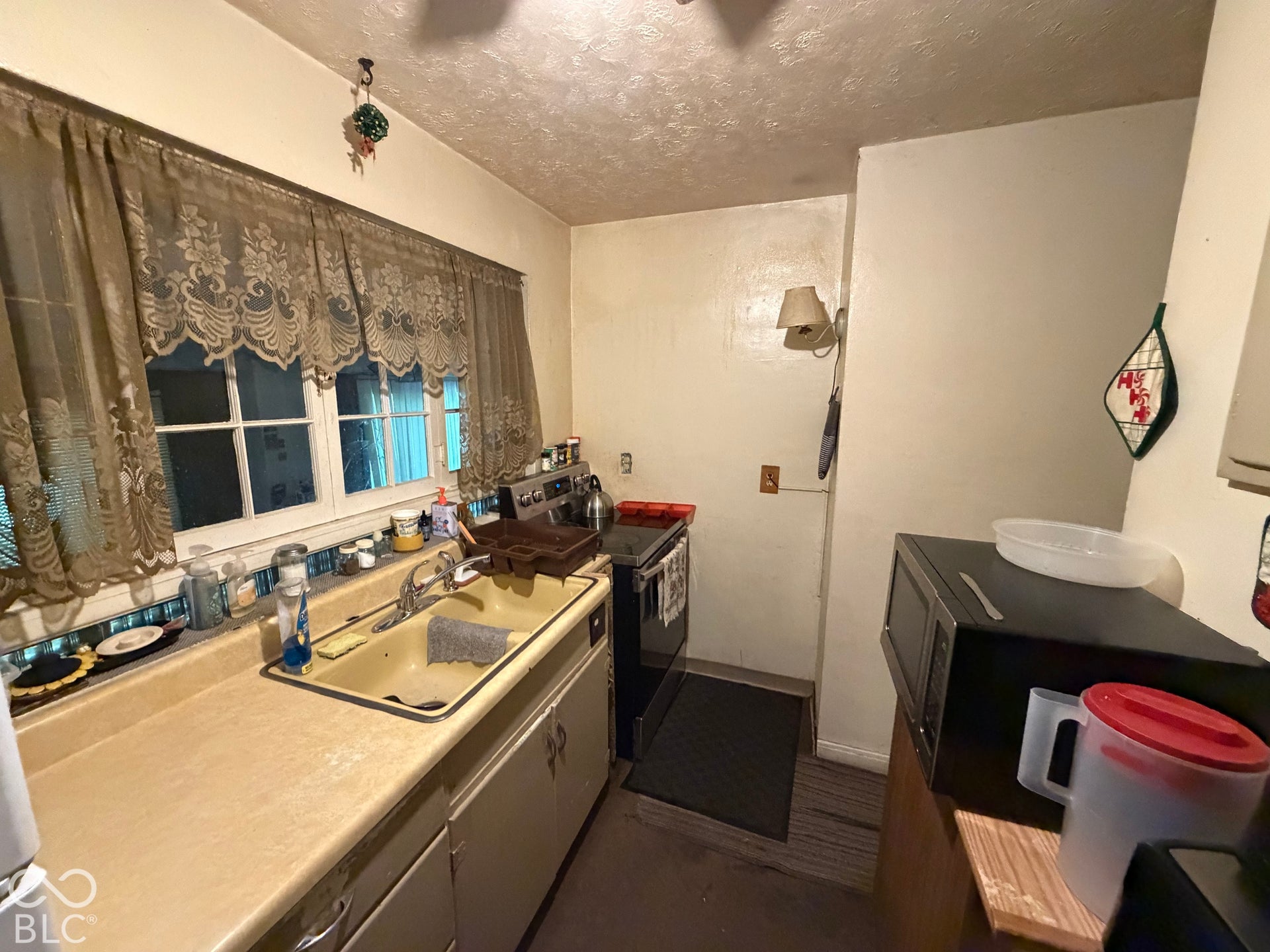 Kitchen featuring a double-basin sink, laminate countertop, and wood-finish flooring