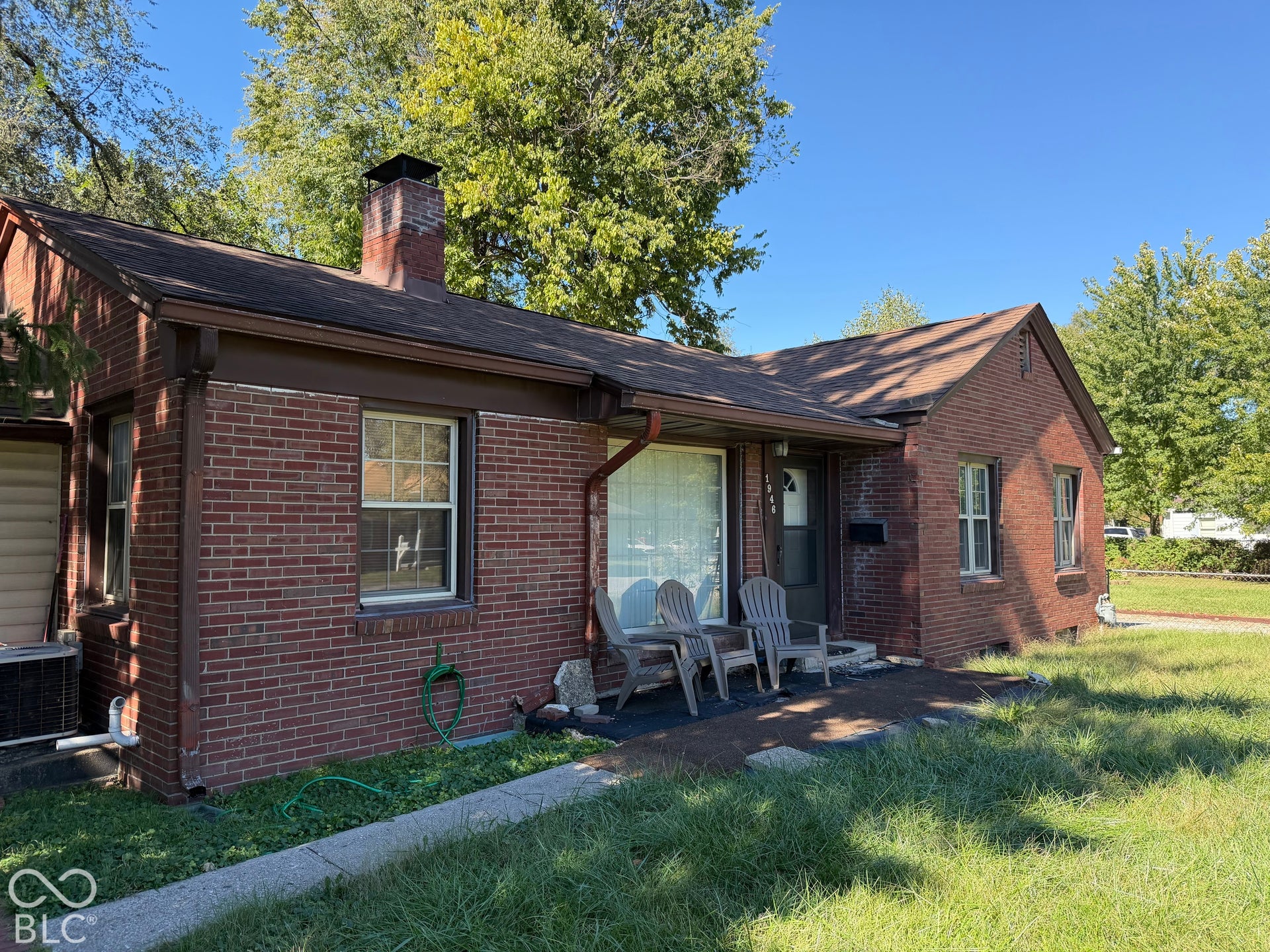 Brick exterior with a prominent brick chimney, gabled roofline, and front entry with a small porch
